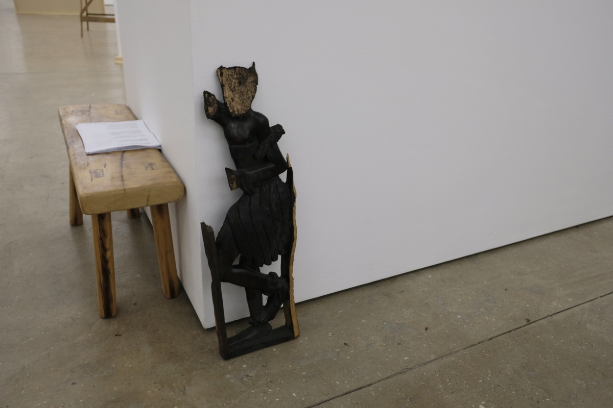 Installation photograph from the 2018 rendition of ‘Parallel Play’ in A4’s Gallery. In the middle, a found wooden sculpture leans against a moveable gallery wall.
