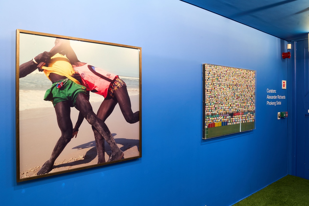 Installation photograph from the 2022 rendition of ‘Exhibition Match’ in A4’s Goods entrance. On the left, Viviane Sassan's photograph ‘La Lutte #2’ and Dan Halter’s mixed media work ‘Study with Colour (Dulux Range)’ are mounted on the wall.
