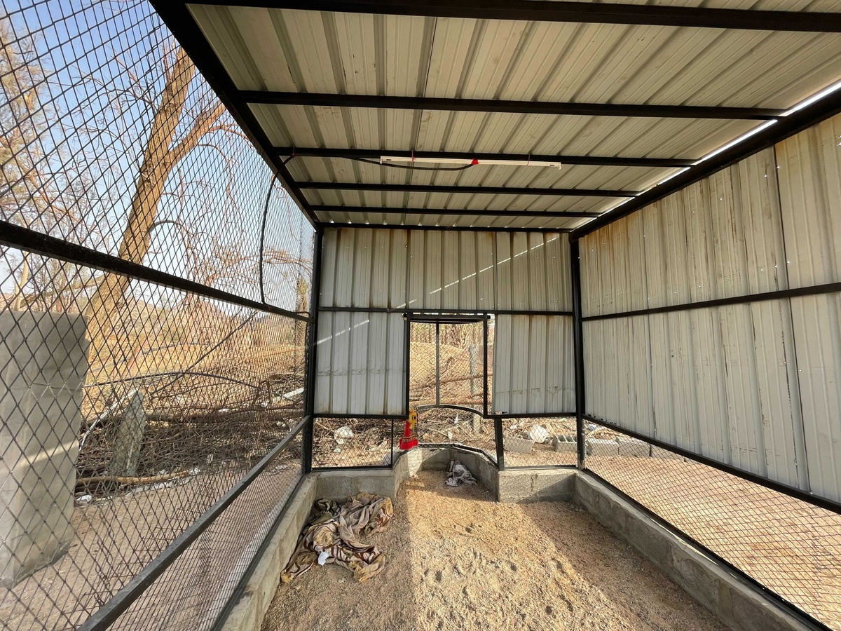 Process photograph from Waiting Upon, Sumayya Vally’s Course of Enquiry at A4, depicting a roadside mosque in Saudi Arabia. In the middle, a cubic structure made from metal beams, mesh and corrugated metal plates sits on a base outlined in brick.
