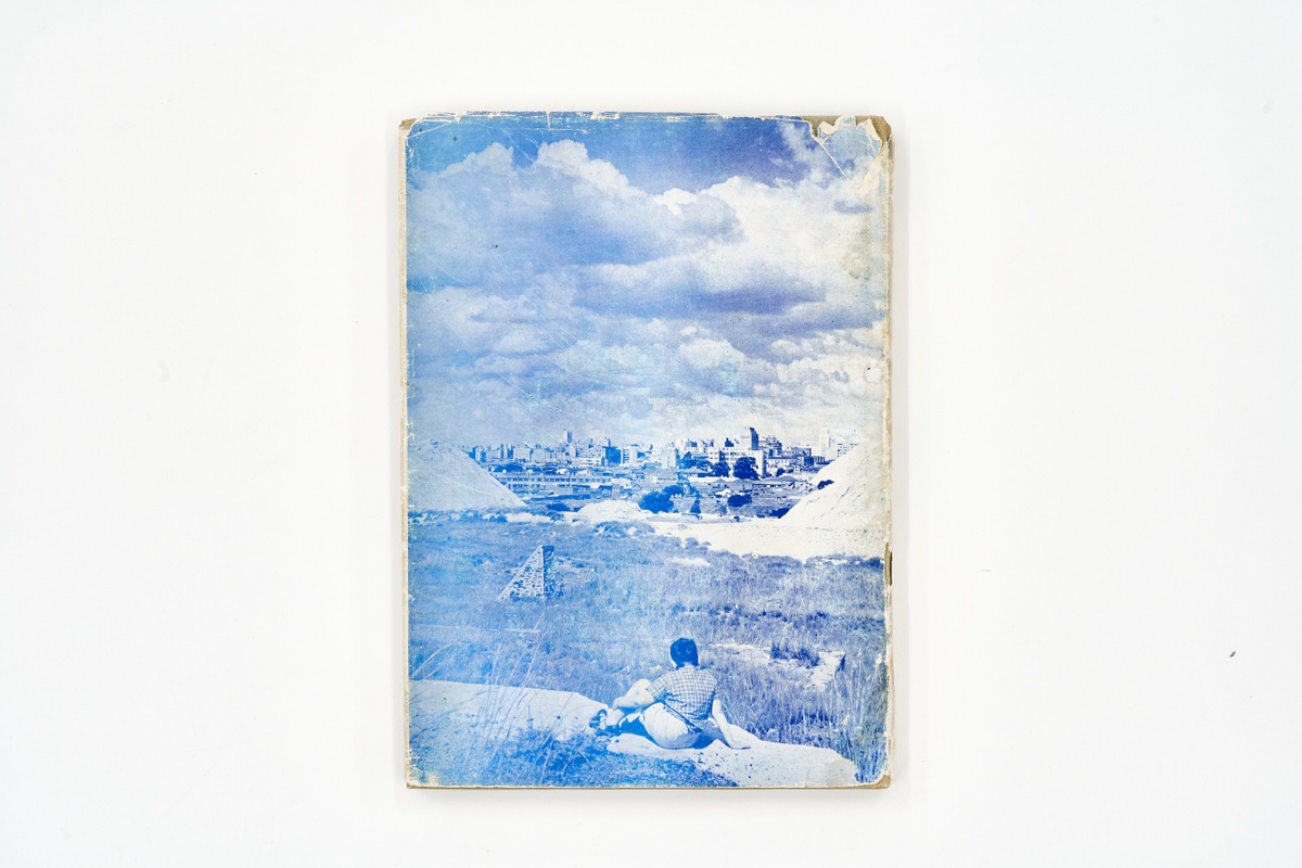A topdown photograph of the back cover of Ezra Eliovson's photo-book 'Johannesburg: The Fabulous City' on a white background.
