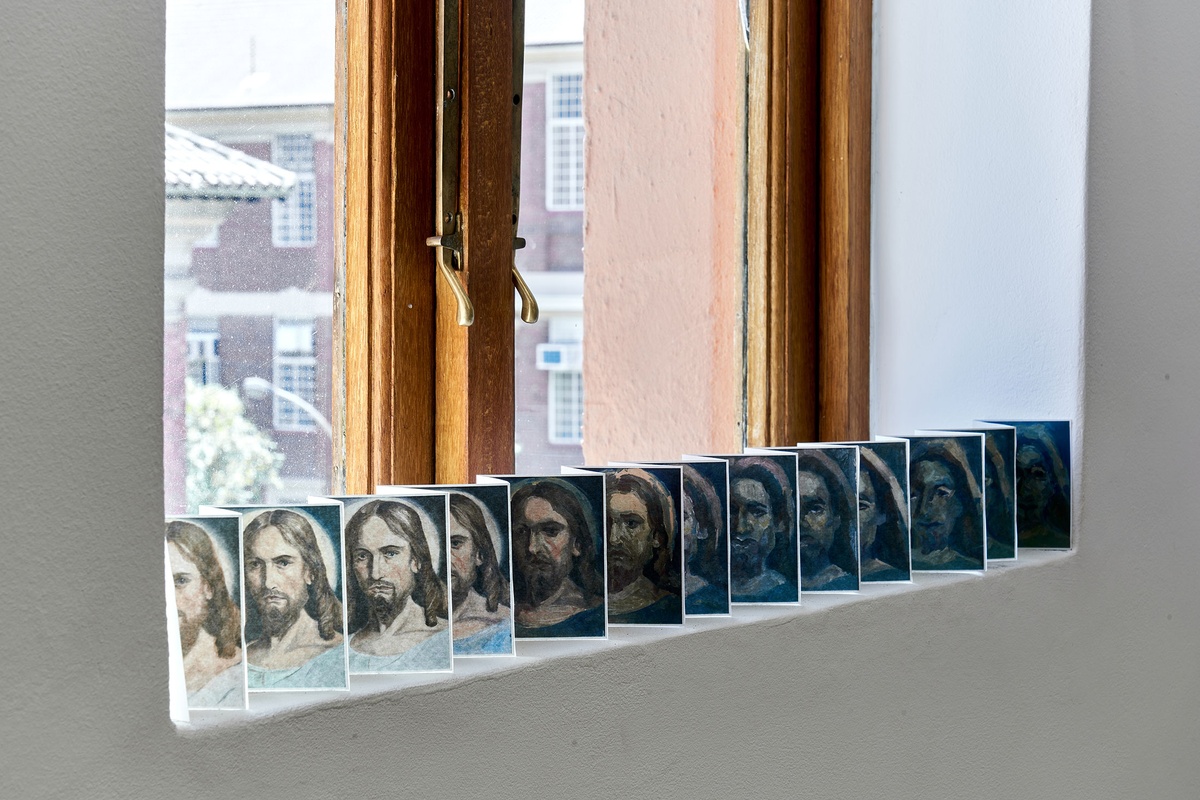 Process photograph from Patrick Waterhouse's 2022 residency in A4 Arts Foundation's studio. On the left, a windowsill holds a small paper accordion with photographic prints.
