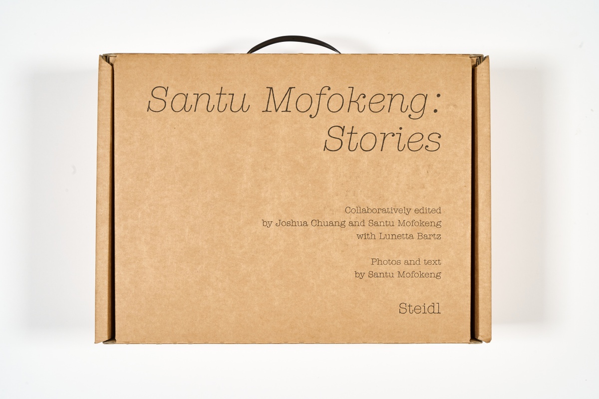 A topdown photograph that shows the packaging for Santu Mofokeng's photo-book 'Stories' on a white background.
