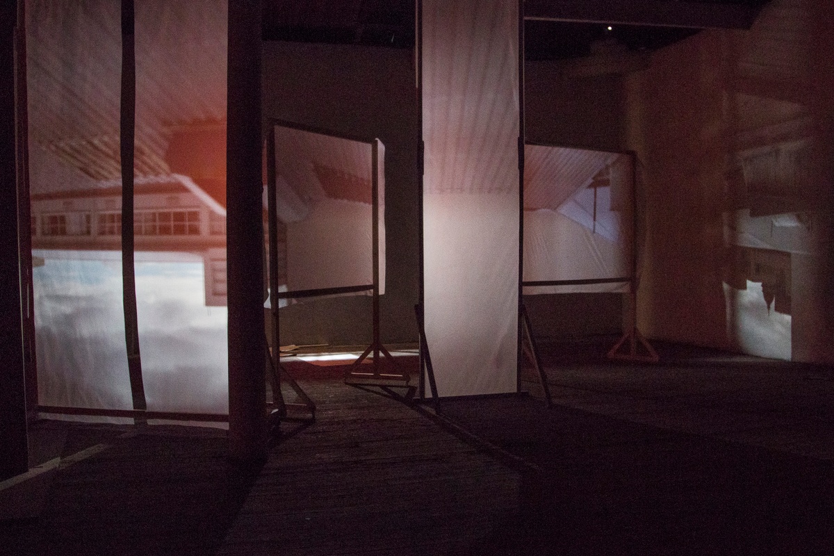 Installation photograph from George Mahashe’s ‘Camera Obscura #3’ exhibition on A4’s top floor. The darkened space features freestanding surfaces with a projected images from A4’s exterior facilitated by Mahashe’s pinhole camera.
