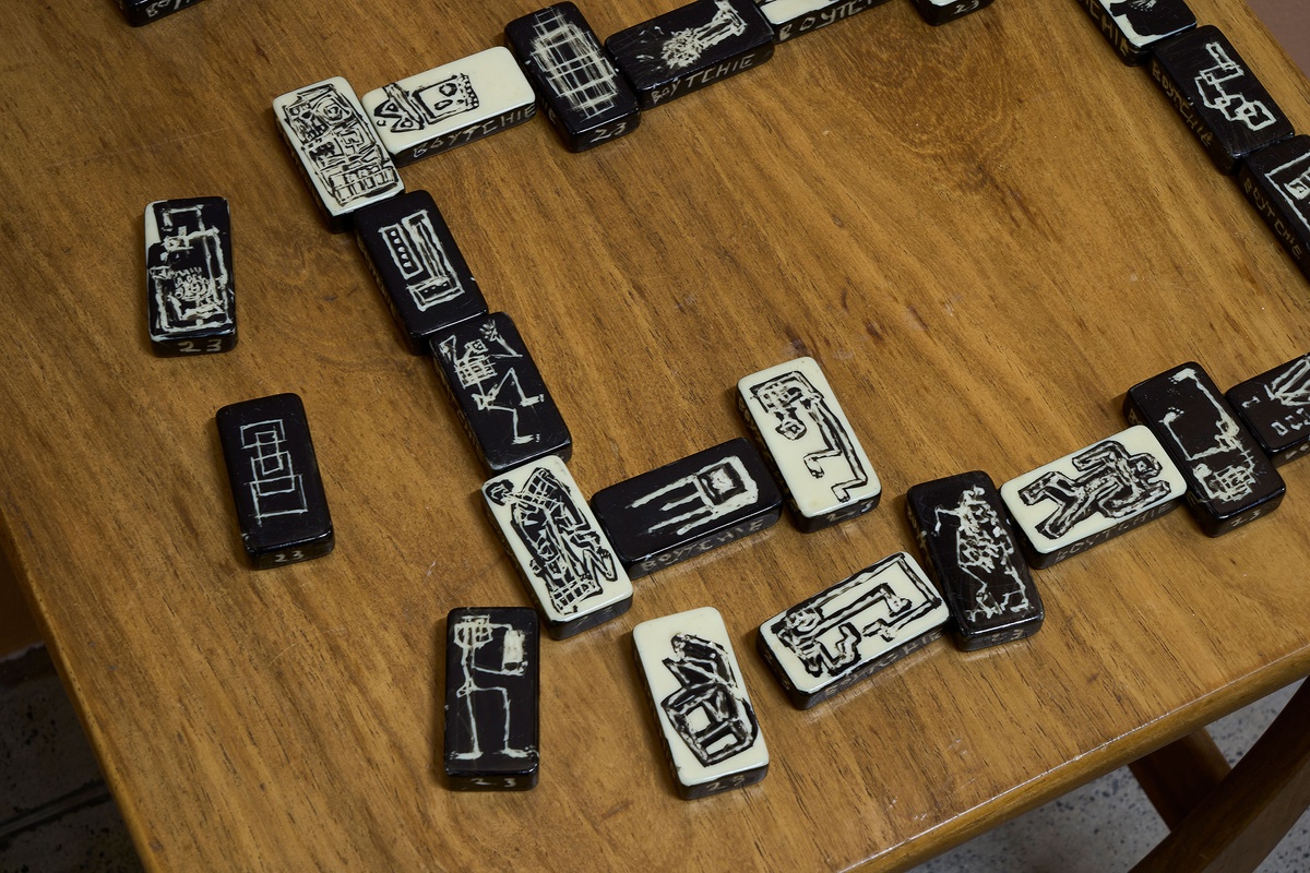 Installation photograph from Phillip Newman's exhibition in A4 Arts Foundation's Goods space shows drawings on small oblong objects arranged on a wooden table.
