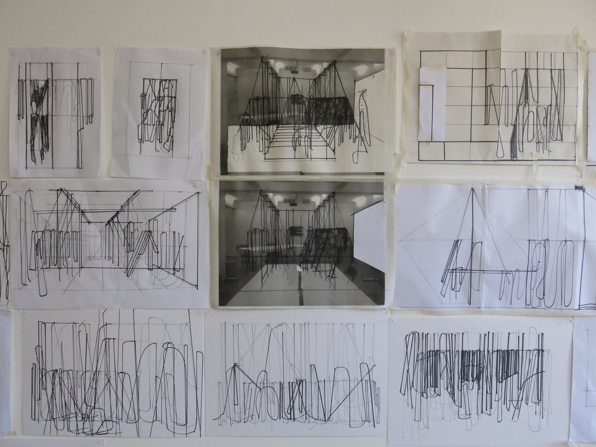 Process photograph from Unathi Mkonto’s residency on A4’s top floor that shows the wall of A4’s studio lined with drawings on white paper and overlaying printed photographs of A4’s ground floor Reading Room.

