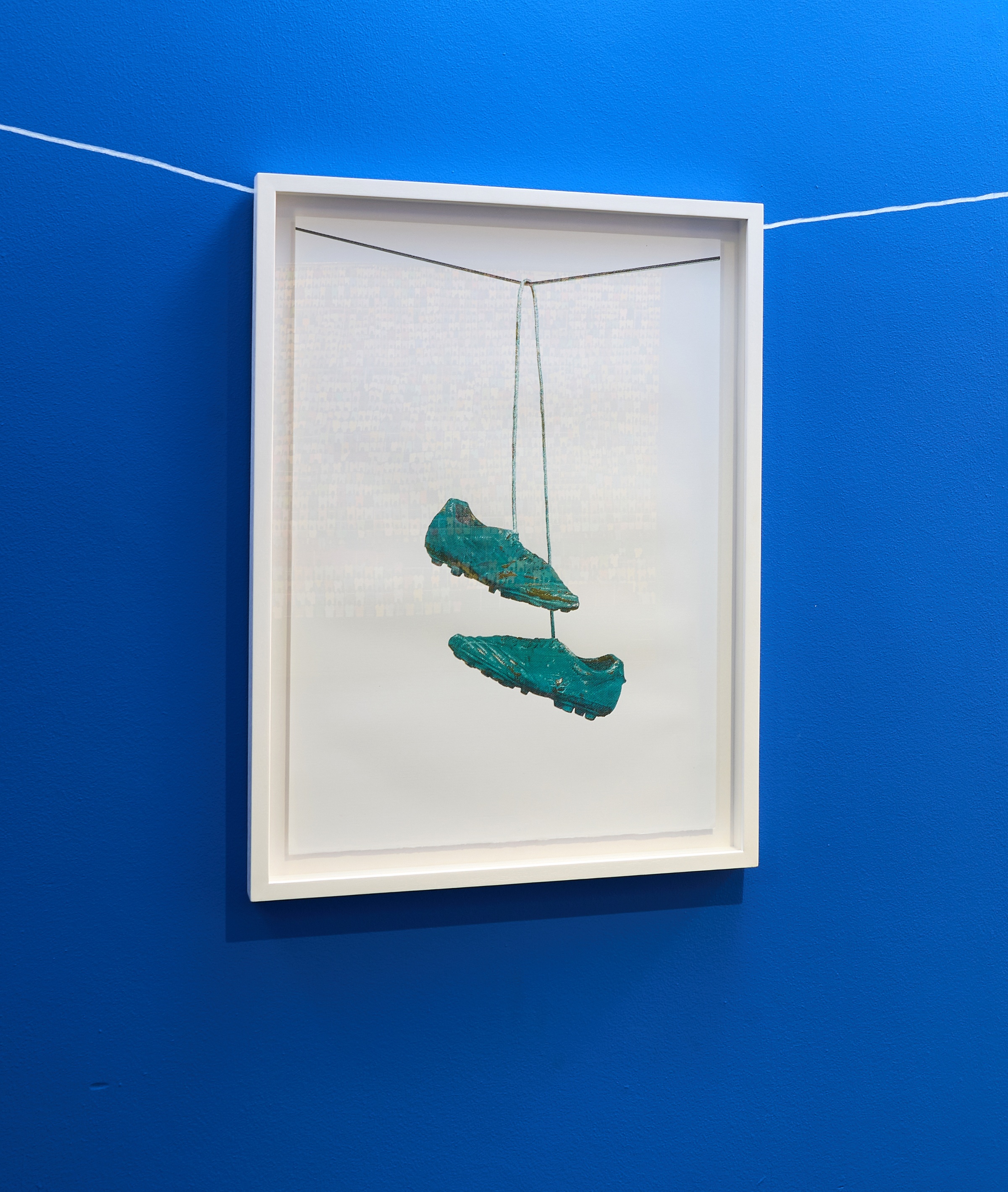 Haroon Gunn-Salie and Aline Xavier's colour screen print 'On the line' depicts a pair of soccer boots suspended from a line.
