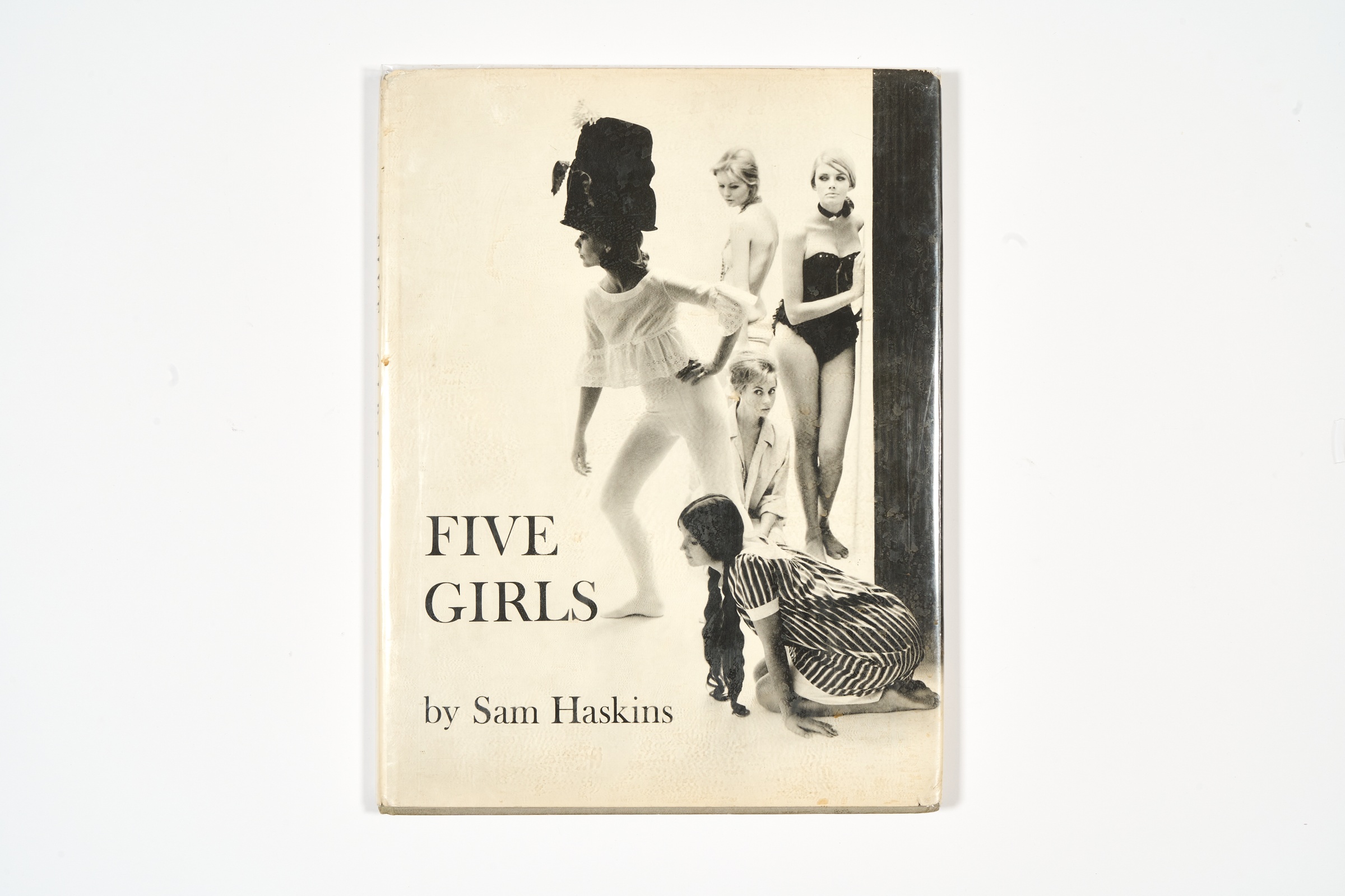 A topdown photograph of the cover of Sam Haskins' photo-book 'Five Girls' on a white background.
