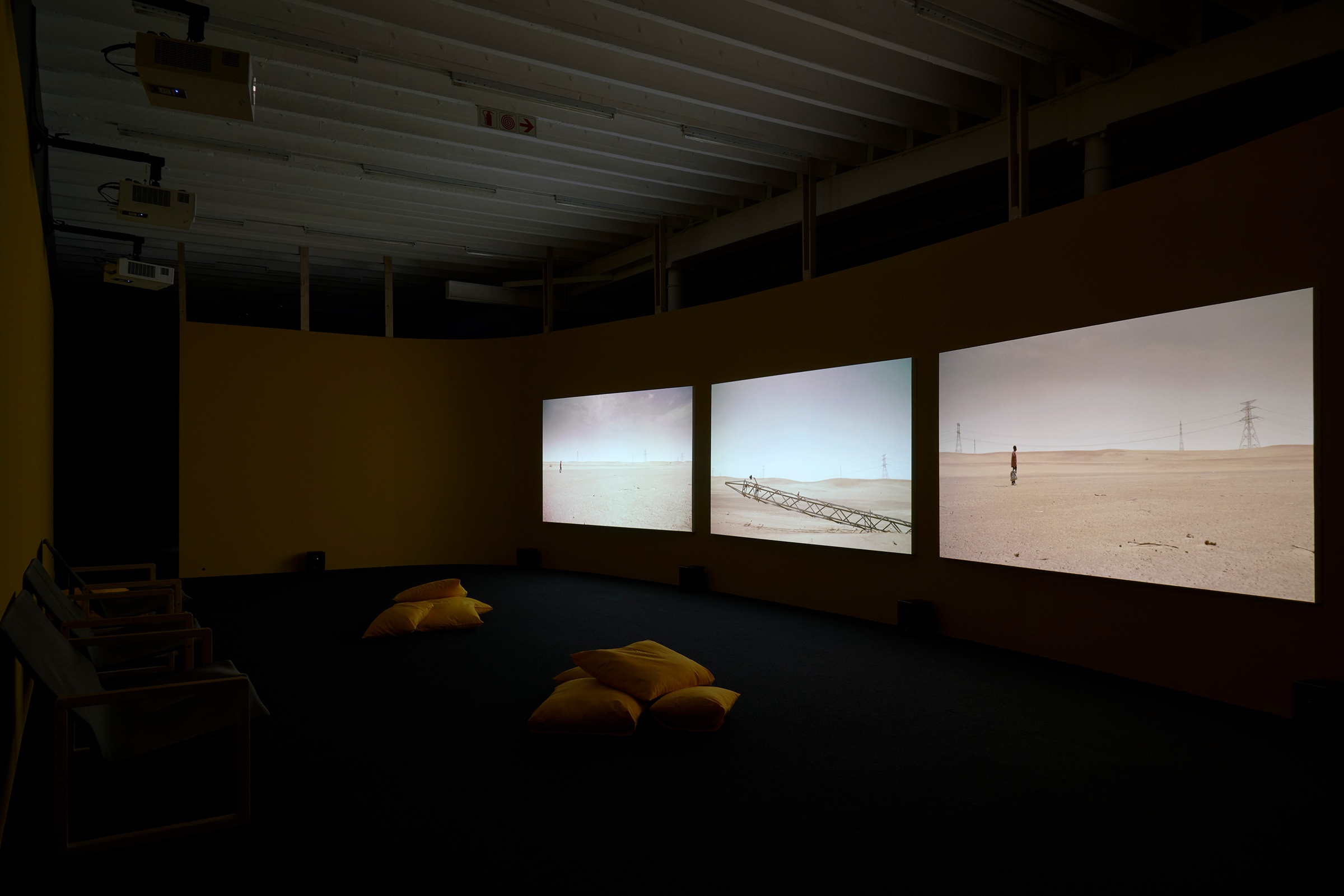 Installation photograph from the ‘Risk’ exhibition in A4’s Gallery. On the right, John Akomfrah’s three-channel video installation ‘Four Nocturnes’ is projected onto the gallery wall.
