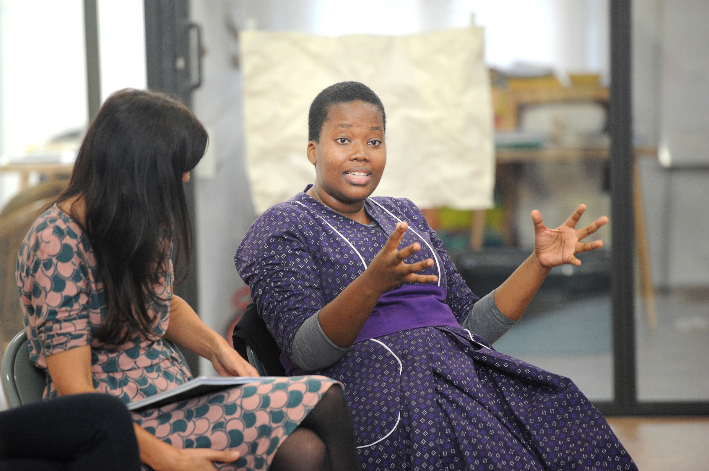 Event photograph from ‘Storied Woman’ on A4’s top floor that shows two seated women in conversation.
