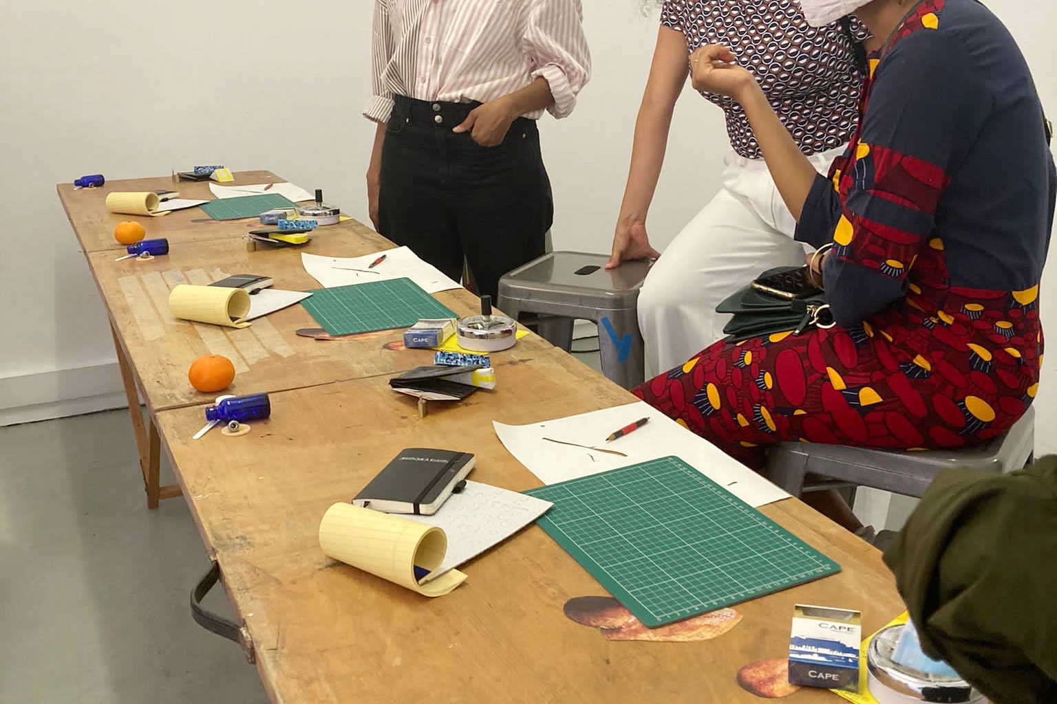 Event photograph from the Investec Cape Town Art Fair 2022 and A4’s joint Curators’ Exchange. A studio visit to Atlantic House with Bulumko Mbete, Frida Robles Ponce and Khanya Mashabela assembled at a studio table.
