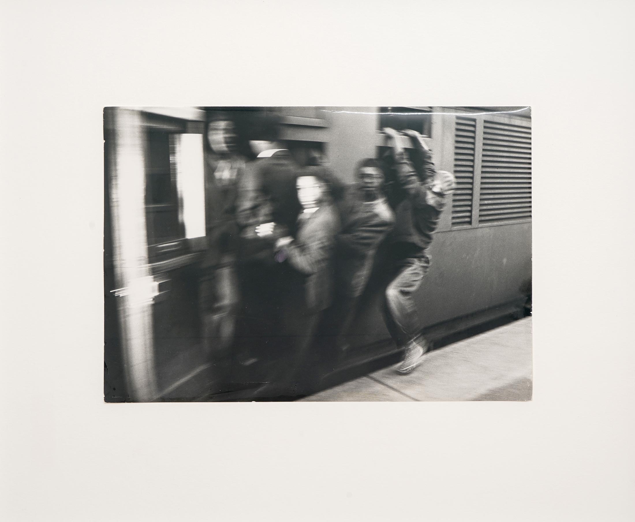 Ernest Cole's monochrome photographic print 'Untitled' depicts individuals boarding a train.
