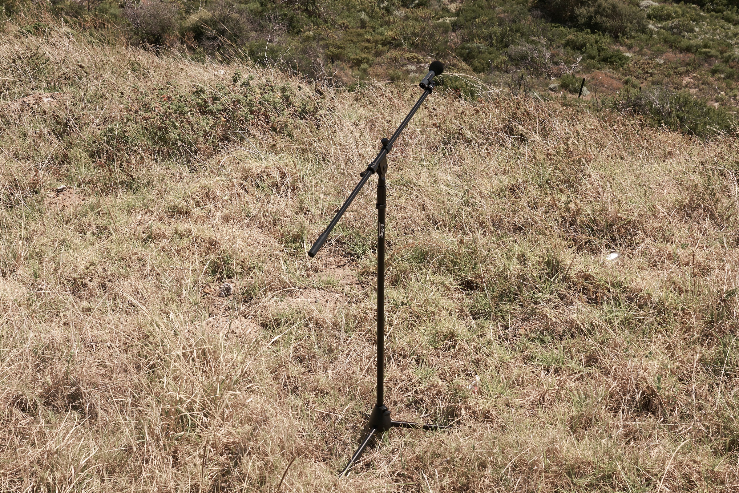 Process photograph from the ‘without a clear discernible image’ exhibition in A4’s Gallery, that shows a single microphone stand in field from Kevin Beasley’s four channel audio installation ‘without a clear discernible image’.
