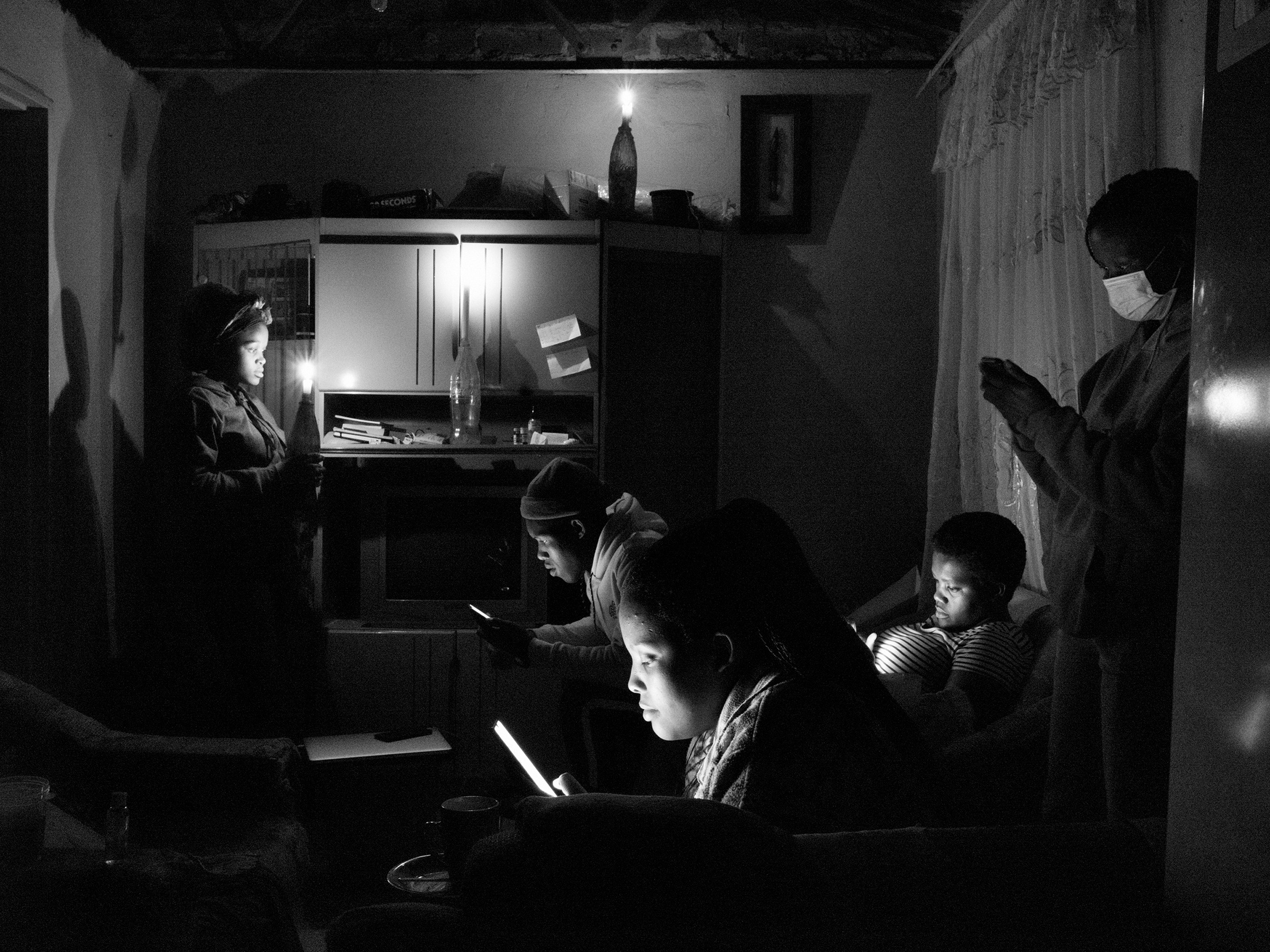 Lindokuhle Sobekwa's photograph 'Death of George Floyd' shows a group of individuals in candle lit room look at their cellphones.
