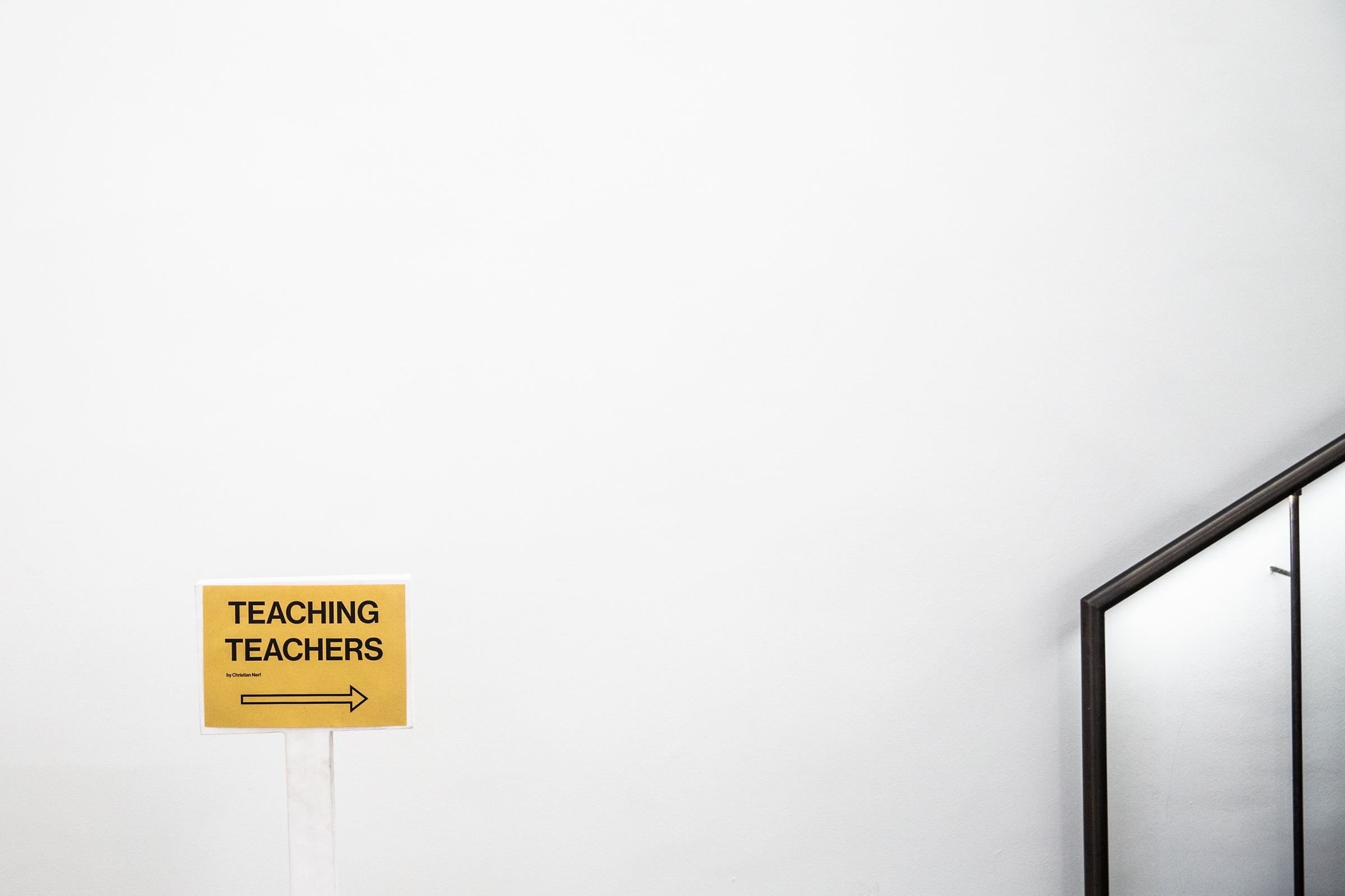 Event photograph from Christian Nerf’s participatory artwork ‘Teaching Teachers’ on A4’s ground floor. At the back, a small poster shows participants where the artwork will take place.
