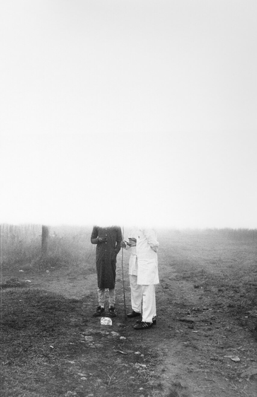 Sabelo Mlangeni's monochrome photographic print 'A morning after (UmlindeloUmlindelo wamaKholwa)' shows two individuals standing on the ground.
