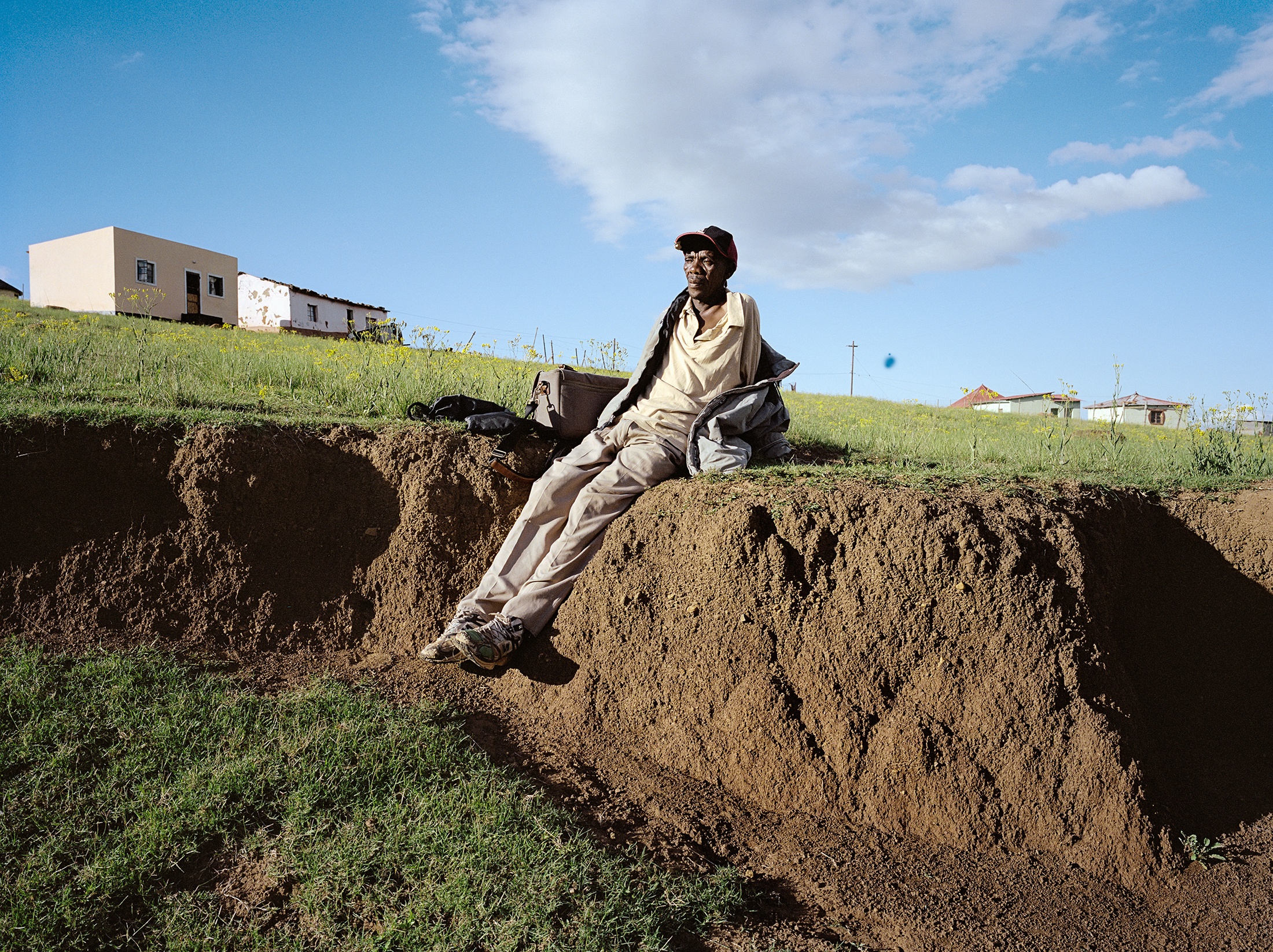 Lindokuhle Sobekwa's photograph 'Ta Mneija' shows an individual sitting on a small outcropping of earth.
