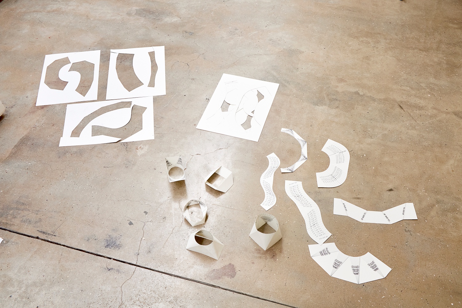 Installation photograph from the 2018 rendition of ‘Parallel Play’ in A4’s Gallery. Paper cutouts with pencilled measurements from Kyle Morland’s ‘Library of Forms’ lays on the gallery floor.

