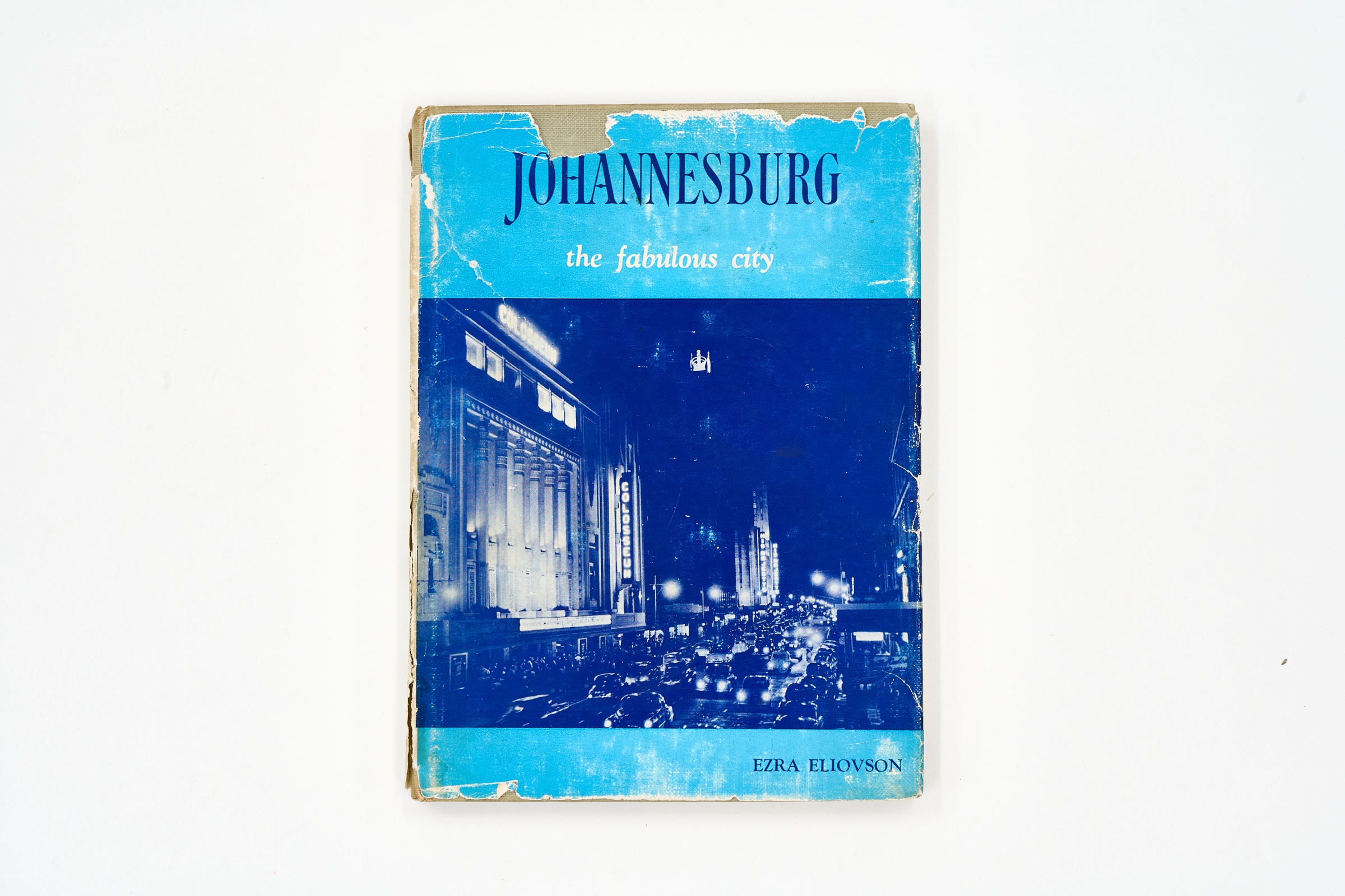 A topdown photograph of the cover of Ezra Eliovson's photo-book 'Johannesburg: The Fabulous City' on a white background.
