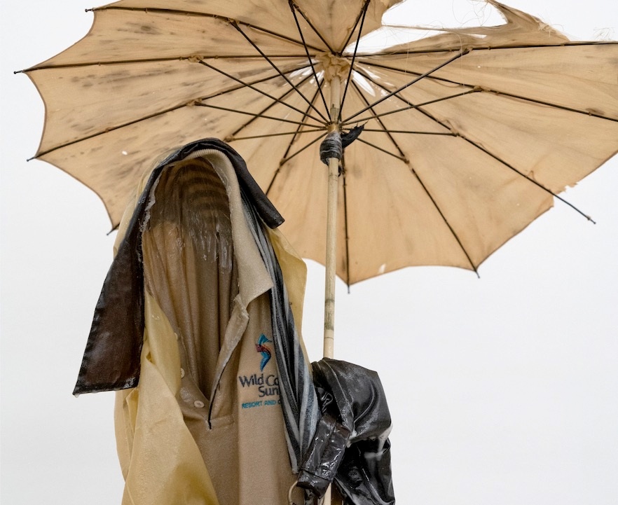 Installation photograph from the ‘without a clear discernible image’ exhibition in A4’s Gallery depicts a detail of Kevin Beasley’s untitled resin sculpture constituted from “aid-to-trade” garments, house dresses, a handbag and an umbrella.
