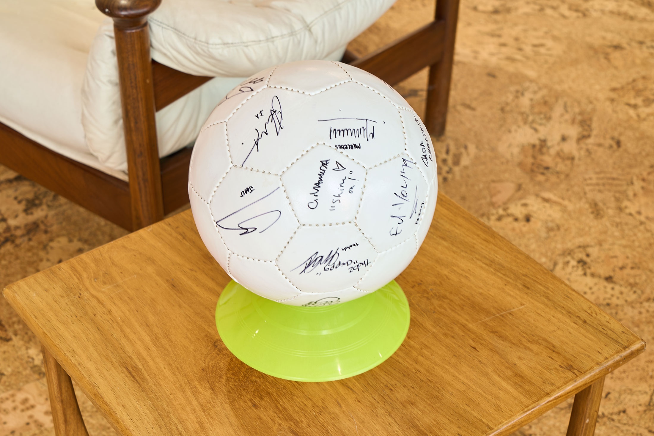 Ephemera from the 2022 rendition of ‘Exhibition Match’ on A4’s second floor. In the lounge, a signed soccer ball rests atop a plastic stand on a coffee table.

