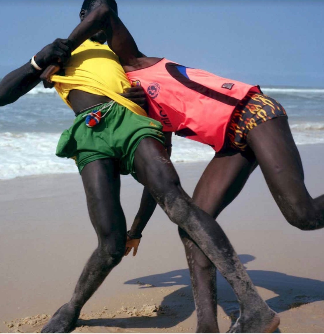 Vivianne Sassen's photograph 'La Lutte #2' shows two individuals on a beach.
