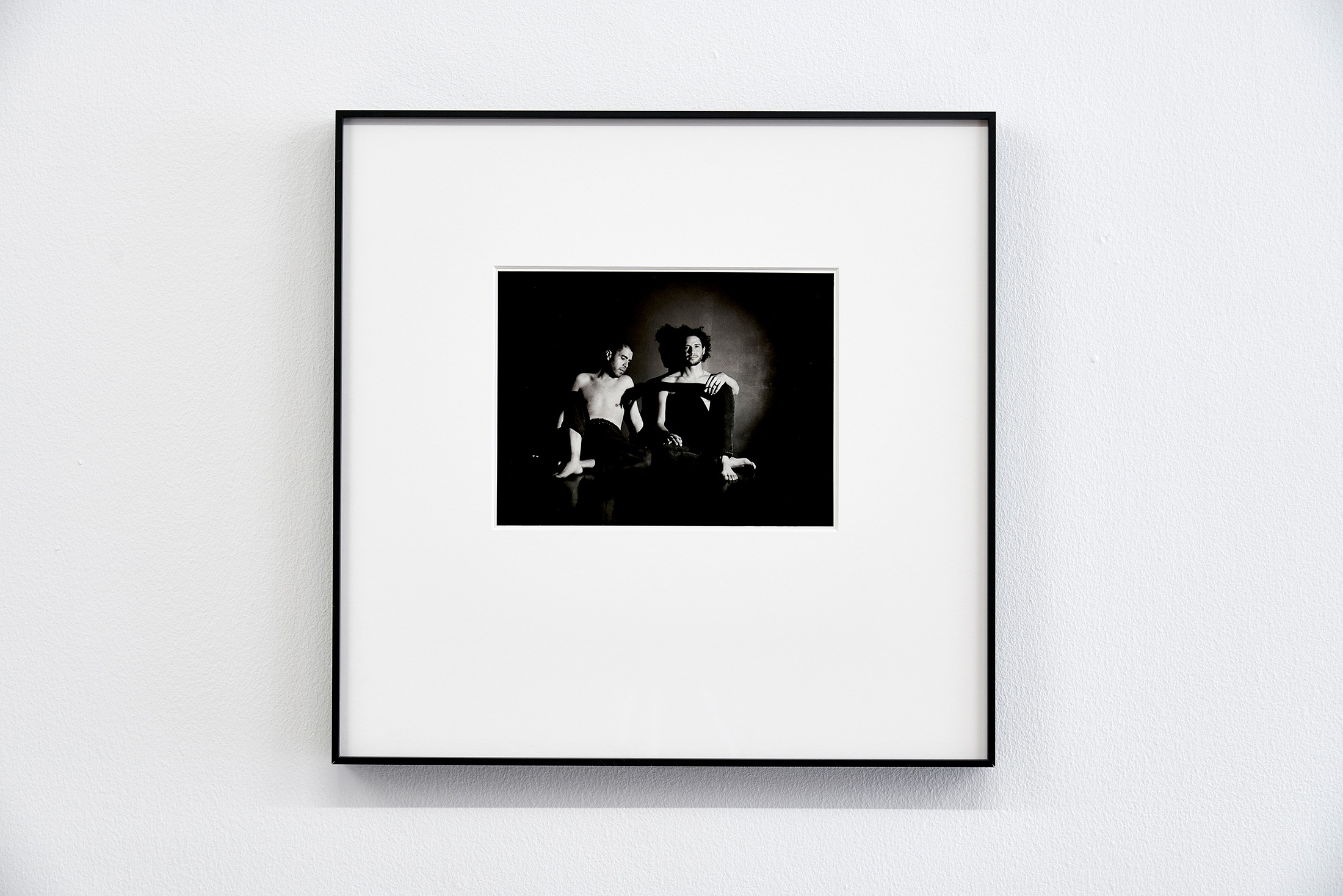 Installation photograph that shows Pedro Slim’s untitled framed monochrome photograph mounted on a white wall.
