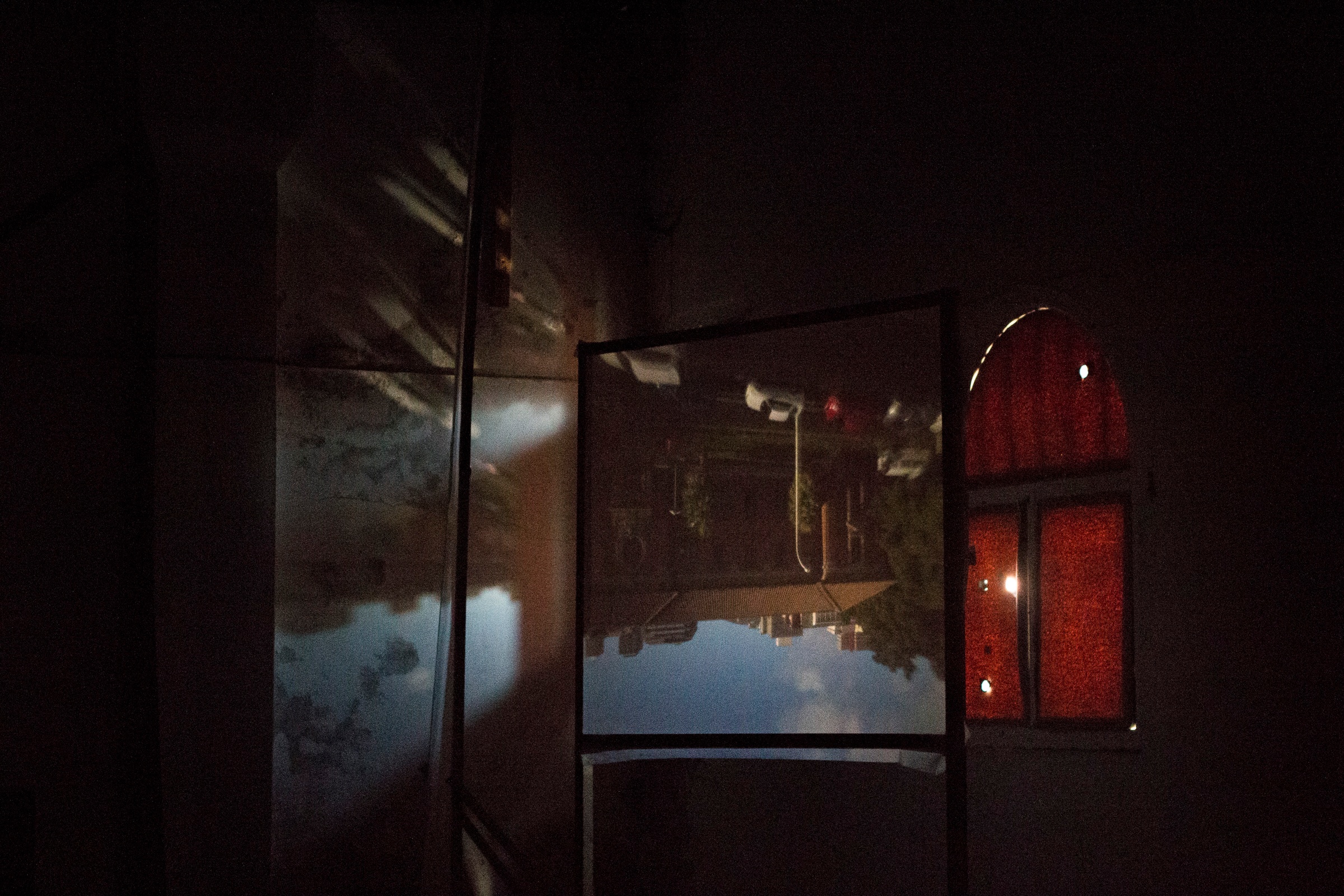 Installation photograph from George Mahashe’s ‘Camera Obscura #3’ exhibition on A4’s top floor. The darkened space features a freestanding surface with a projected image from A4’s exterior facilitated by Mahashe’s pinhole camera.
