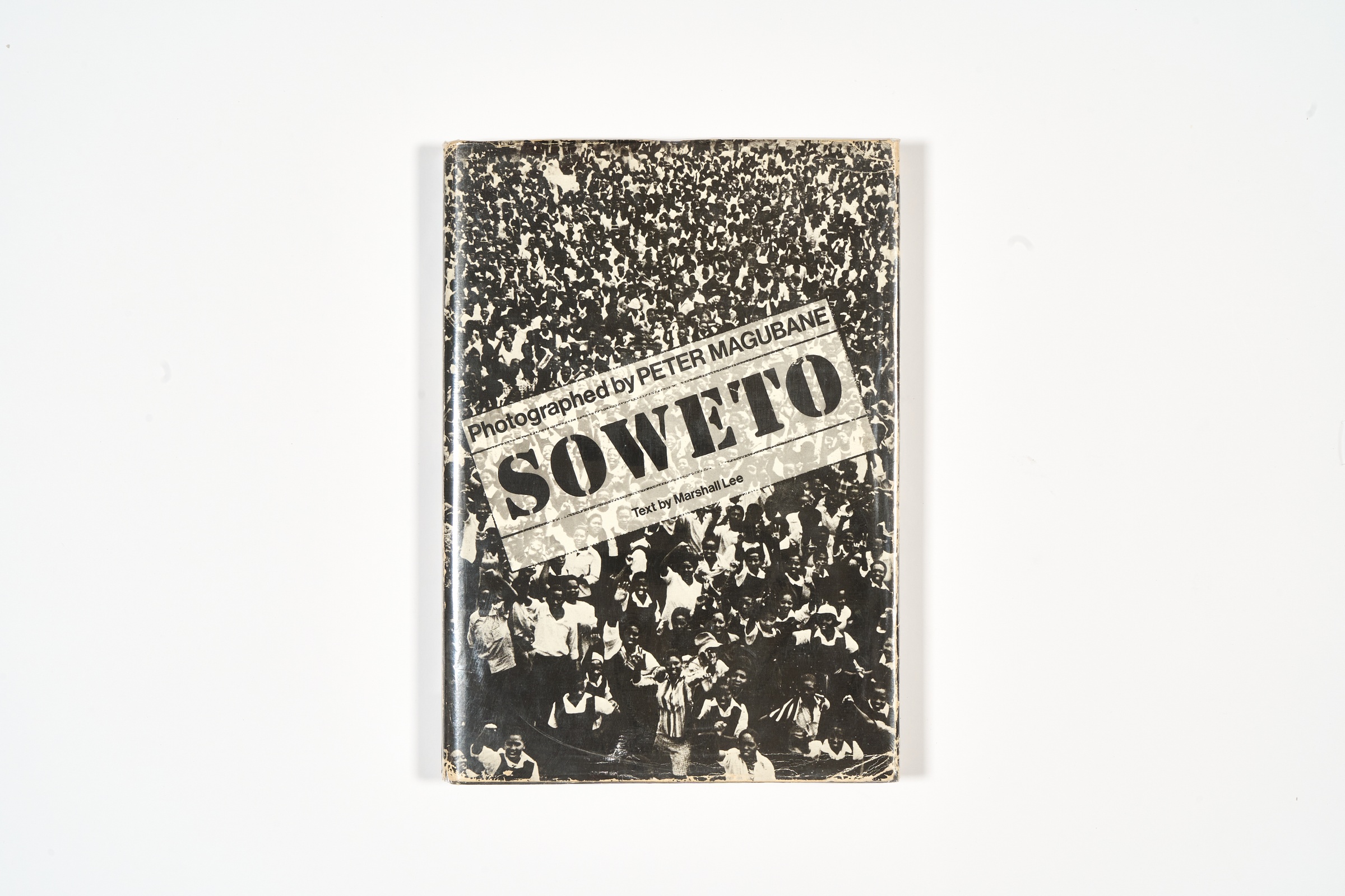 A topdown photograph of the cover of Peter Magubane's photo-book 'Soweto' on a white background.
