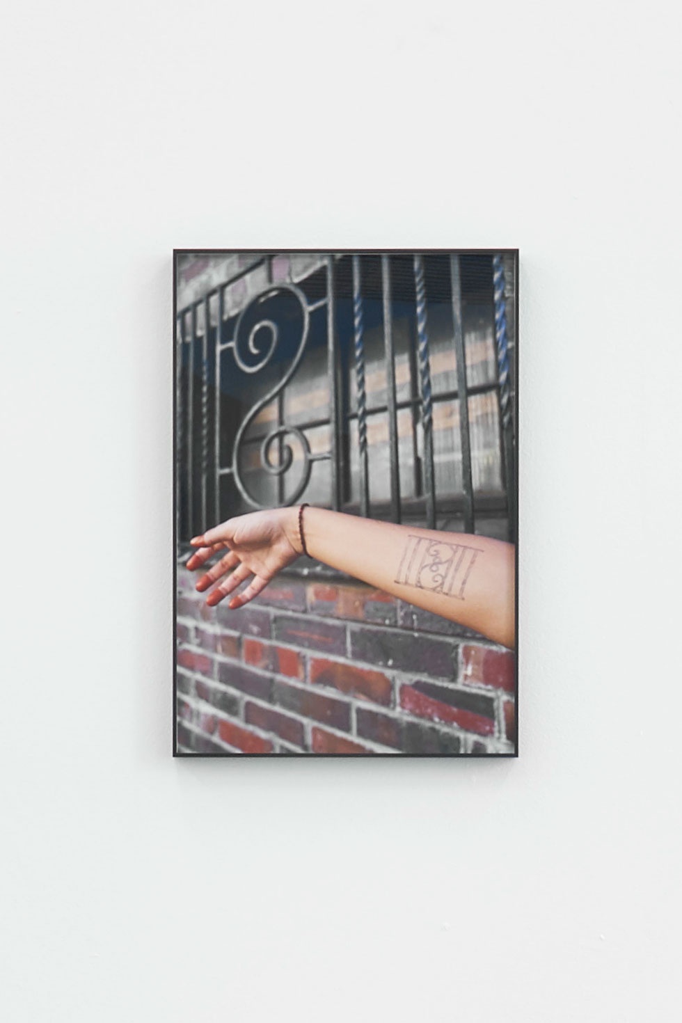 An installation photograph of Kevin Beasley's framed photographic print 'Windows' mounted on a white wall.
