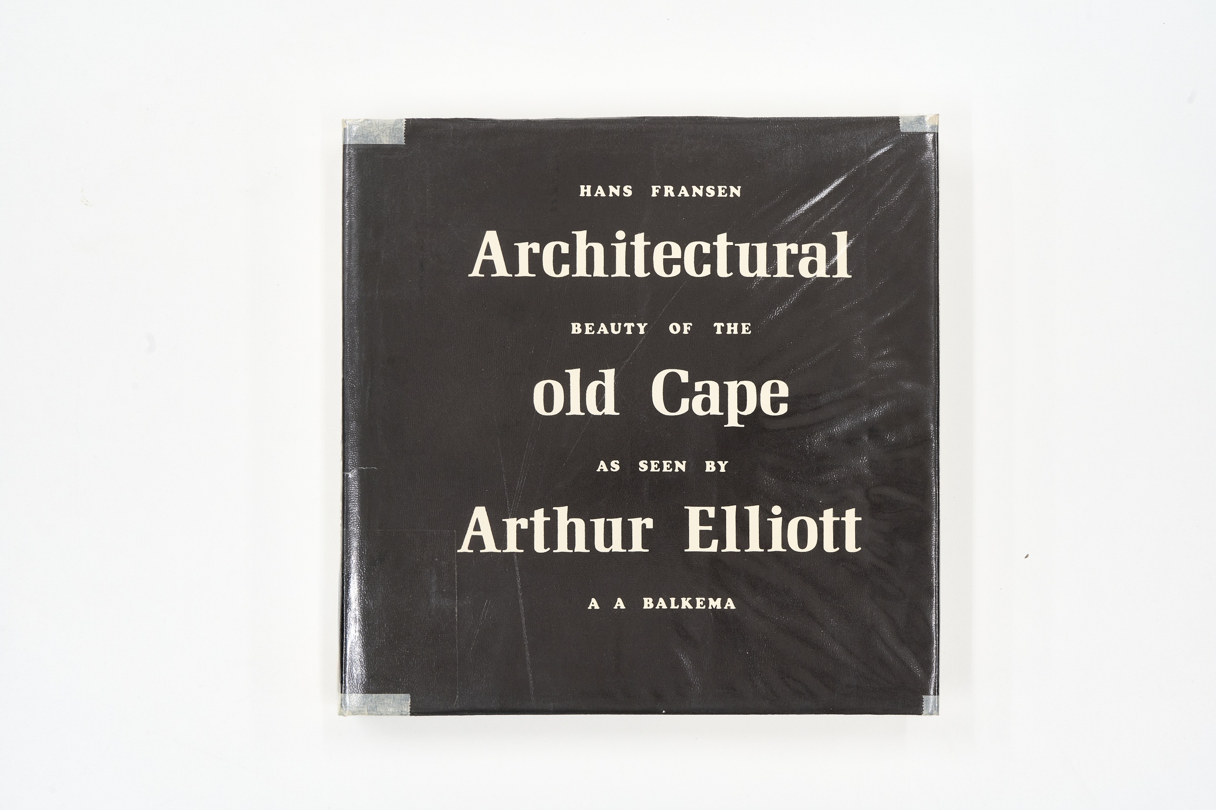 A topdown photograph of the cover of Arthur Elliott's photo-book 'Architectural Beauty of the Old Cape as Seen by Arthur Elliot' on white background.
