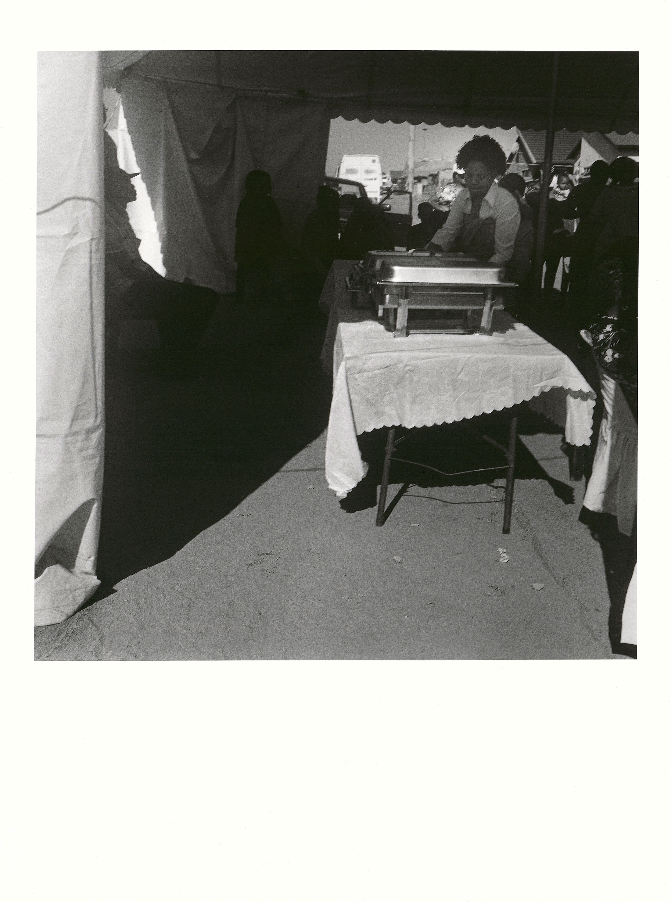 Sabelo Mlangeni’s ‘Buffet catering in silver, Witbank’, a black and white photograph that depicts a wedding buffet in a tent.
