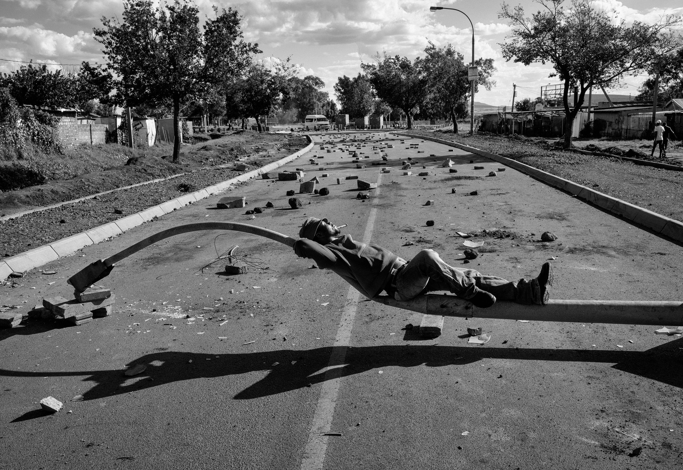 Lindokuhle Sobekwa’s monochrome photographic print ‘After a protest related to continuous power cuts during Lockdown Level 5 in Thokoza’ depicts the aftermath of protest action.

