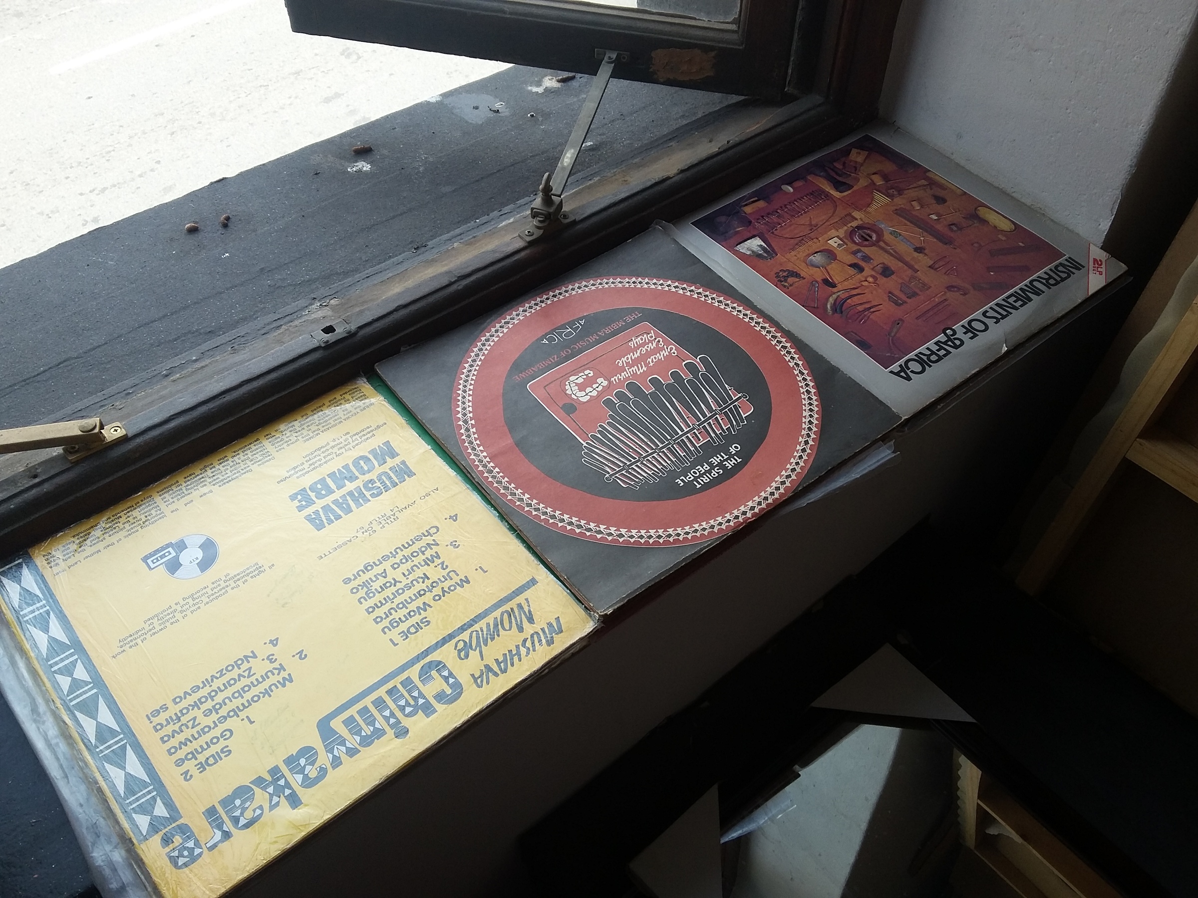 Event photograph from the offsite exchange ‘Pungwe Nights: Listening to Listening’ that shows vinyl records laid out on a windowsill.
