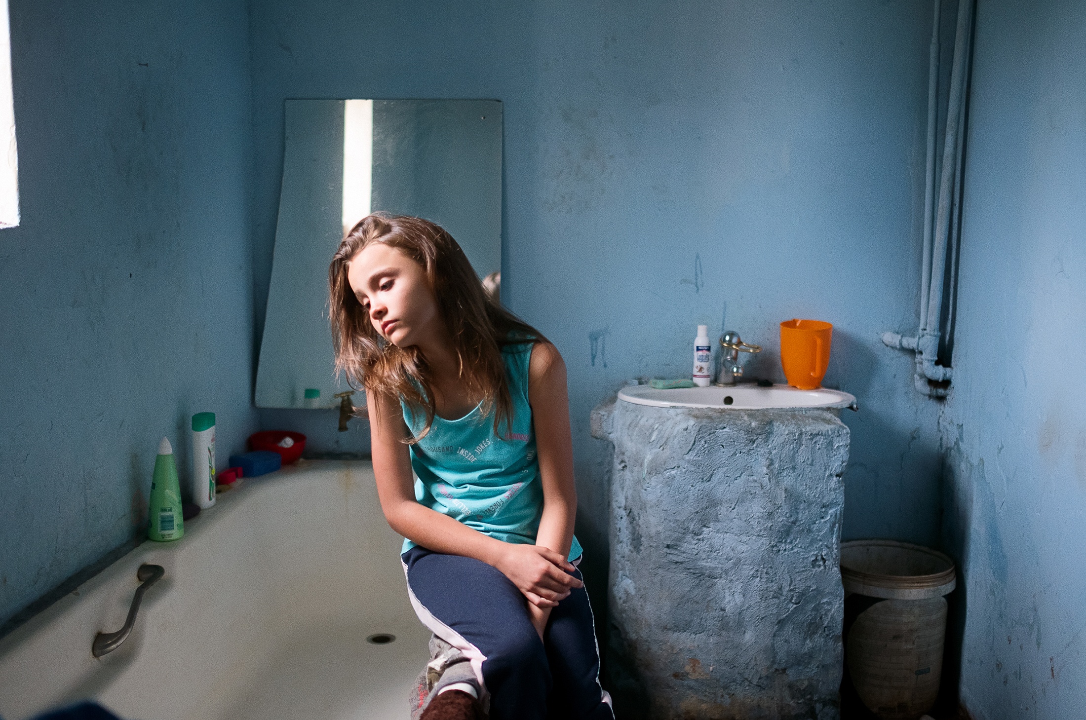 Lindokuhle Sobekwa's photograph 'Morne's younger sister' shows a child sitting on the rim of a bathtub.
