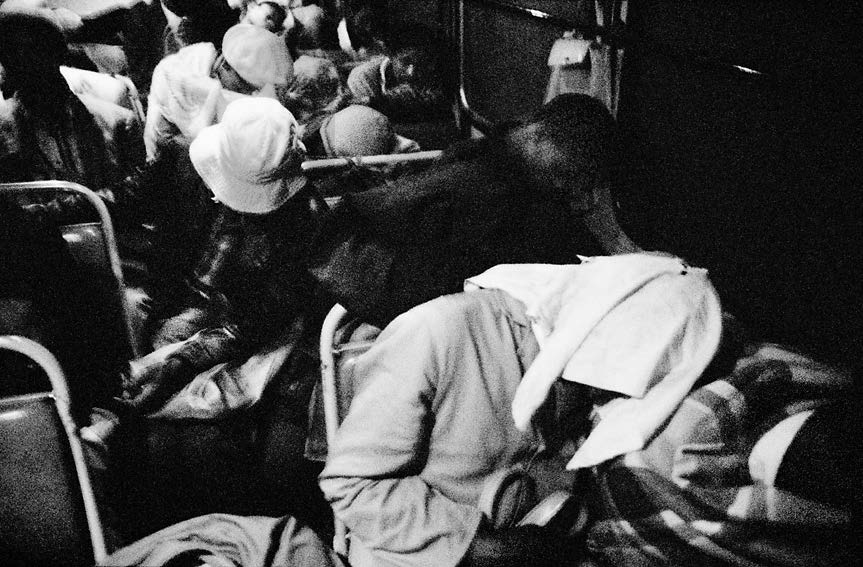 David Goldblatt's black-and-white photograph 'Sitting next to each other, strangers often become intertwined in sleep' shows people asleep on a bus.
