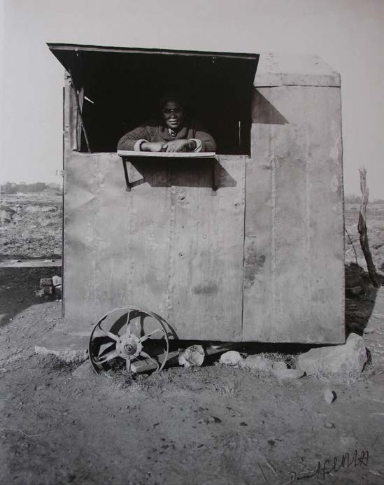 David Goldblatt's monochrome photograph 'Cafe de Move-On, Croesus' shows a mobile cafe leaning on rock supports.
