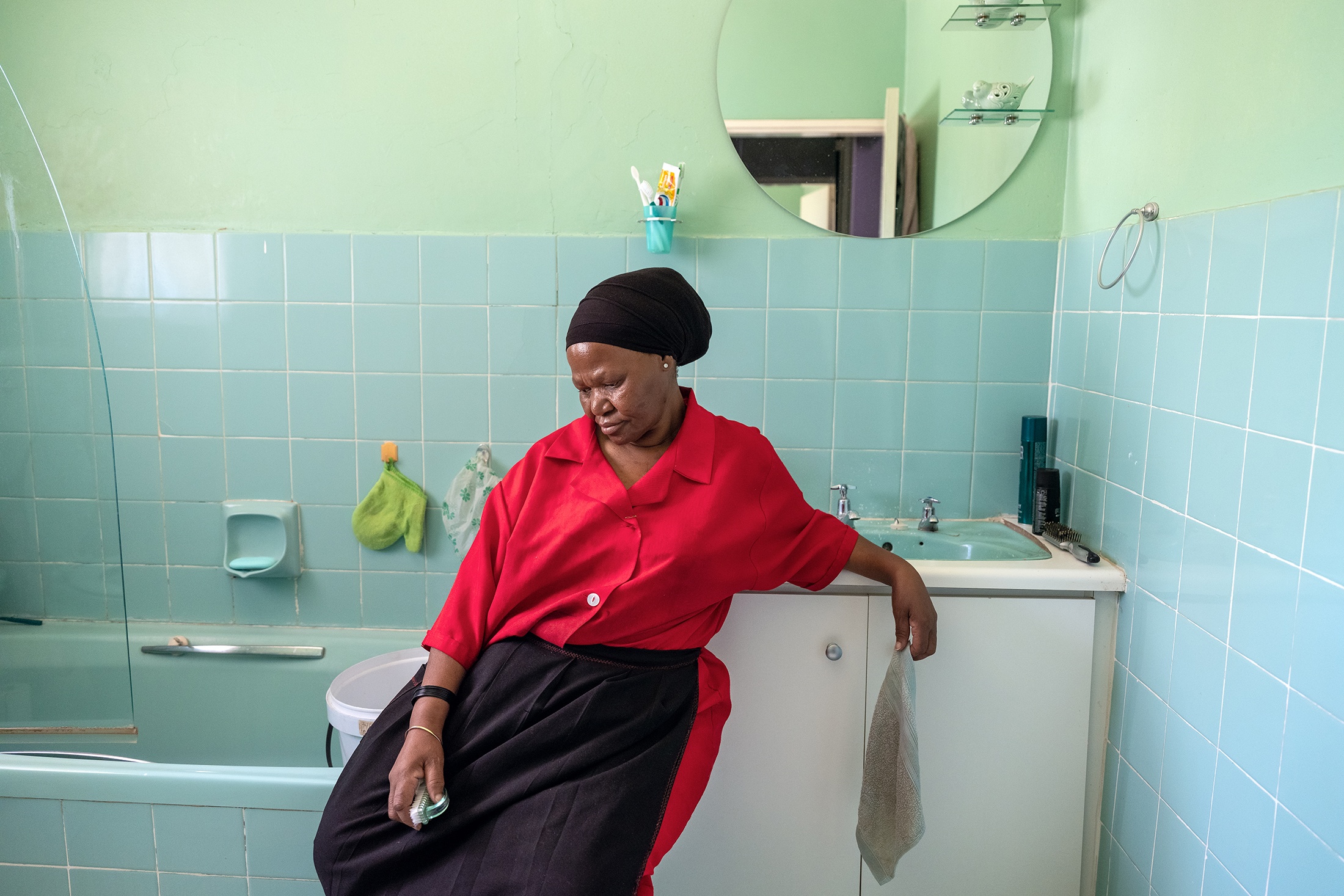 Lindokuhle Sobekwa's photograph 'My mother at work' shows an adult sitting on the rim of a bathtub.
