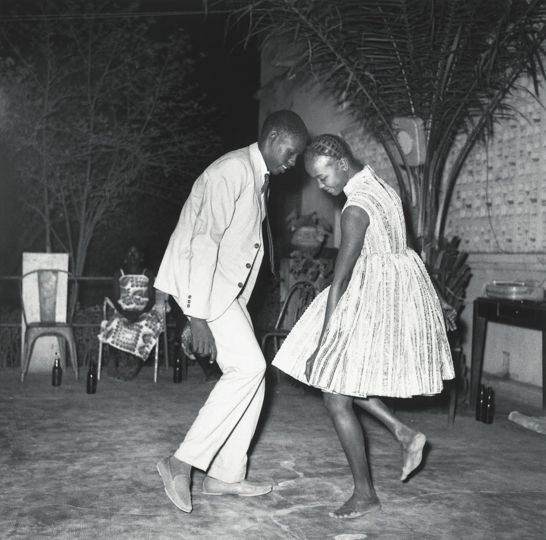 Malick Sidibe's monochrome photograph 'Christmas Eve / Nuit de Noël (Happy Club)' shows two individuals dancing.
