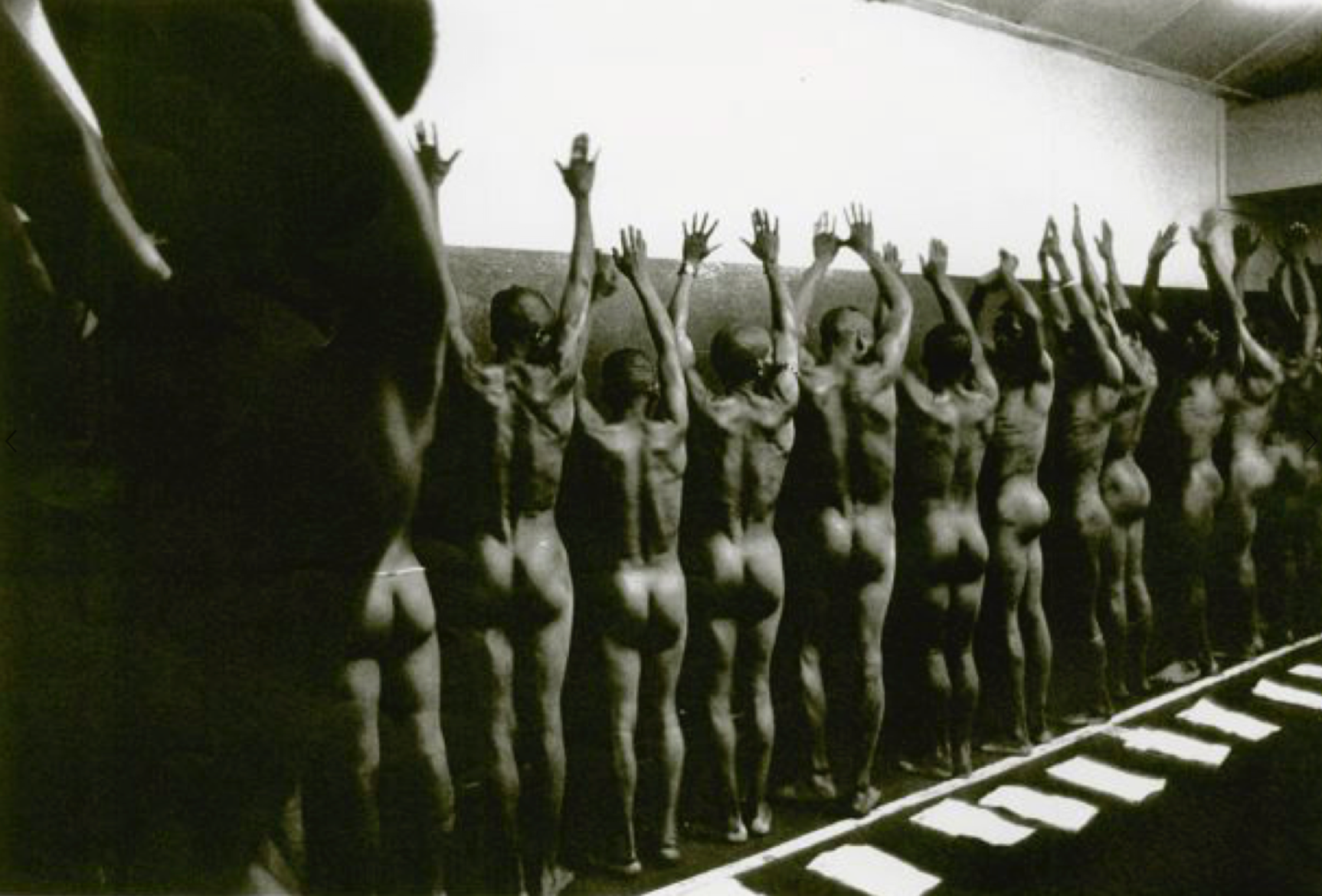 Peter Magubane's monochrome photograph 'Mine recruits humiliated by being forced to strip naked for tuberculosis examination, Witwatersrand'.
