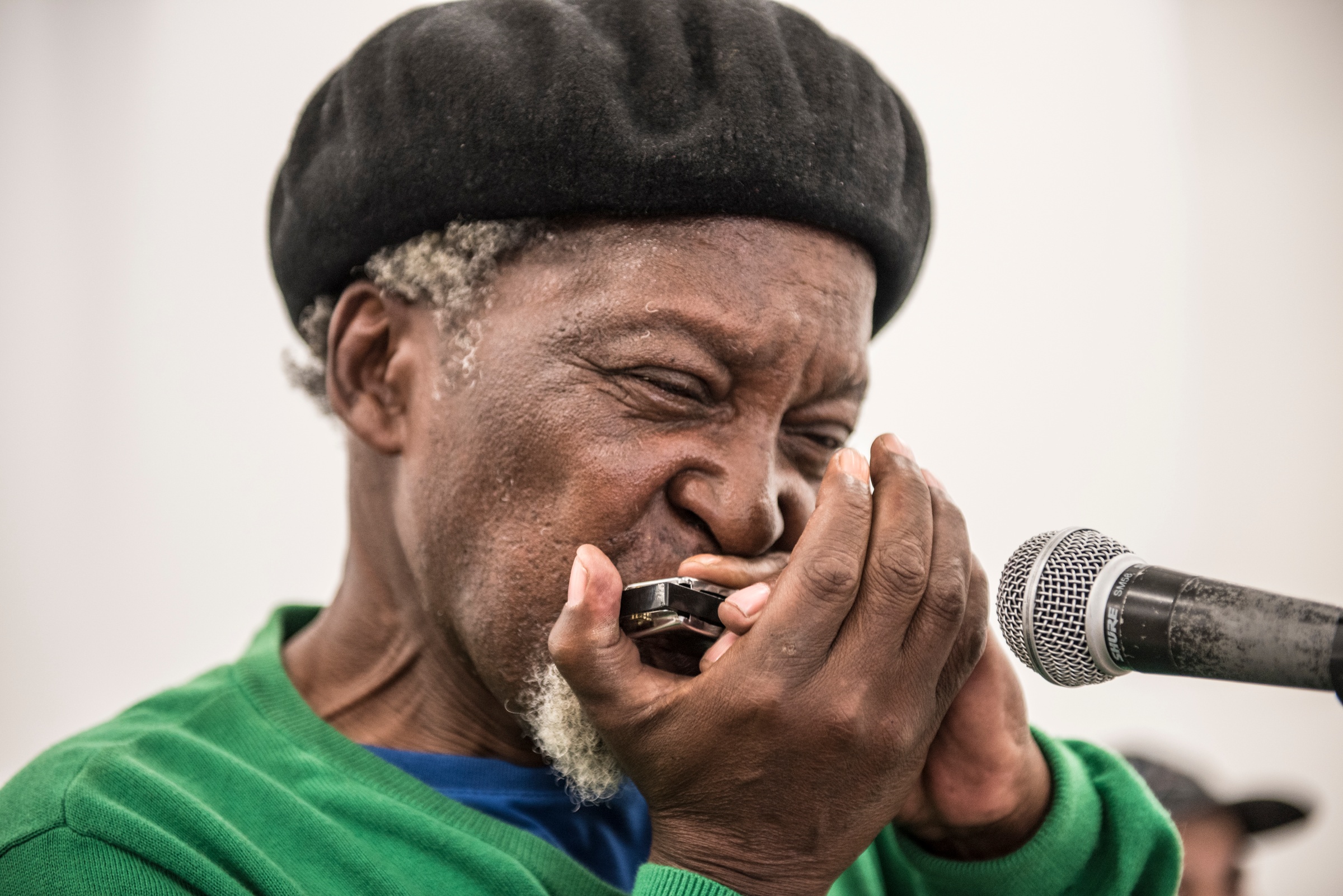 Event photograph from ‘Between Space & Time’ musical performance on A4’s ground floor that shows Lefifi Tladi playing the harmonica.
