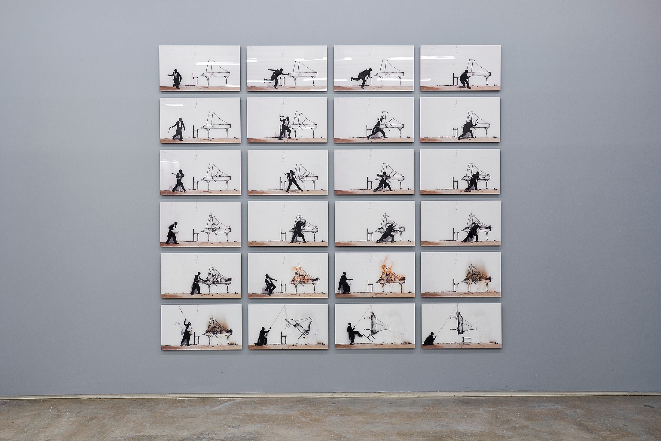 Installation photograph from the ‘Sounding the Void, Imaging the Orchestra V.1’ exhibition in A4’s Gallery. Robin Rhode's photographic series 'Piano Chair' is mounted on a gallery wall in a grid formation.
