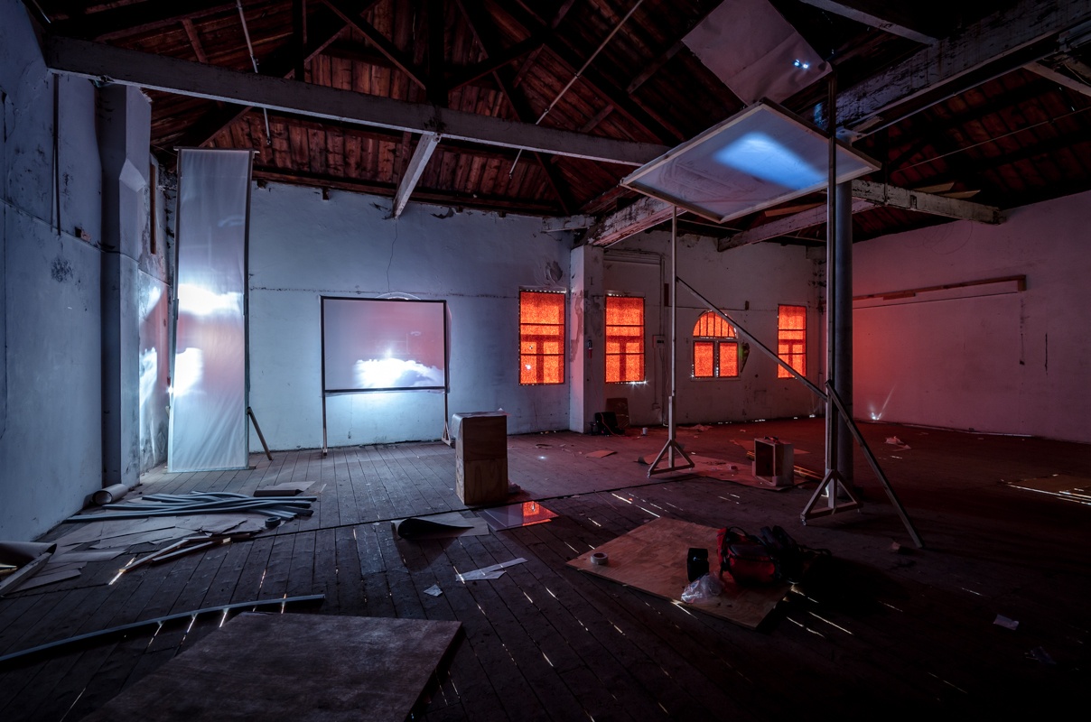 Process photograph from George Mahashe’s residency on A4’s top floor. Three freestanding blank surfaces are arranged around the space so as to catch refracted light from A4’s exterior through Mahashe’s pinhole cameras.
