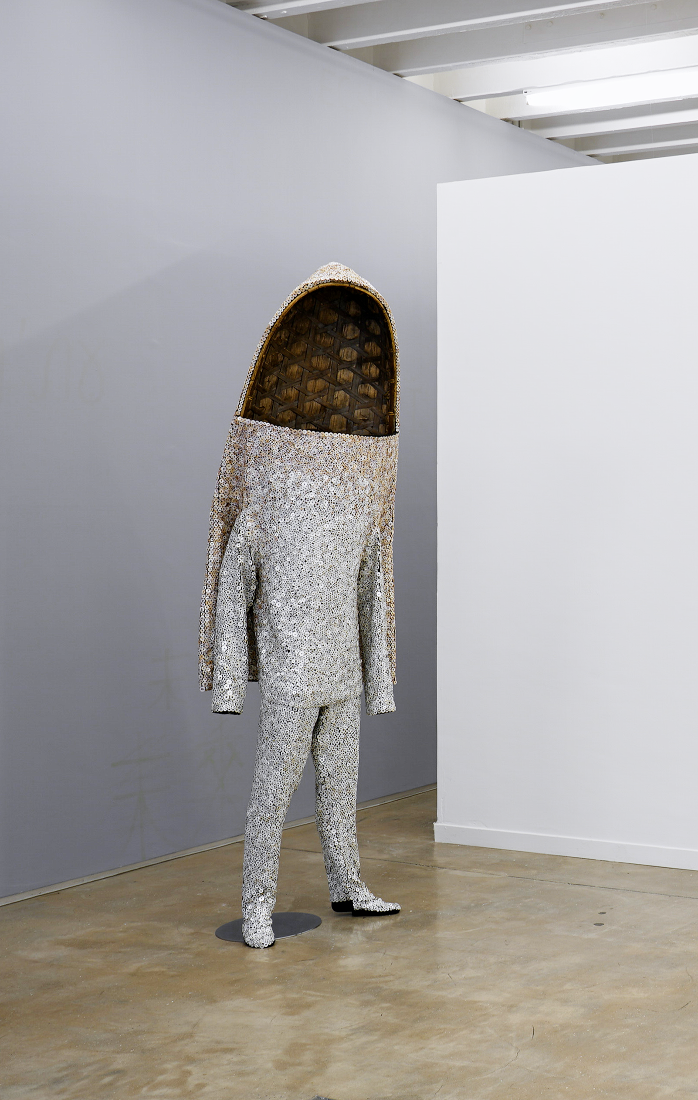 Installation photograph from the ‘Sounding the Void, Imaging the Orchestra V.1’ exhibition in A4’s Gallery. Nick Cave's buttons, wire, bugle beads, basket/wood, upholstery and mannequin sculpture 'Soundsuit' stands on the concrete gallery floor on the left.
