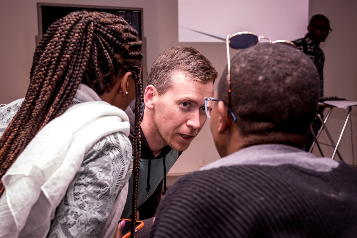 Event photograph from ‘A Game Show Double Bill’ by Kiri Pink Nob on A4’s ground floor, shows three participants huddled together.
