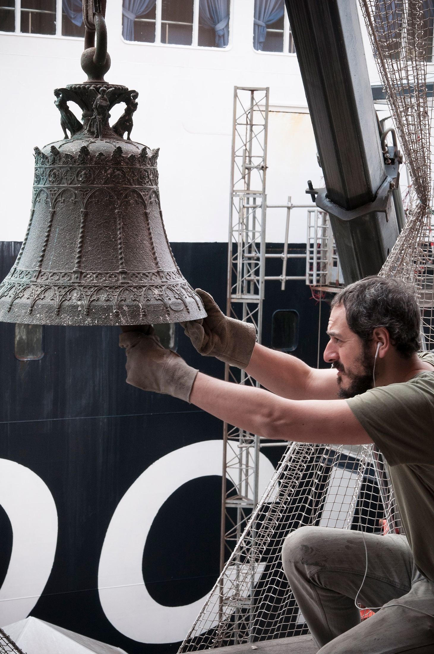 Still frame from ‘Sette Stagioni dello Spirito (Seven Seasons of the Spirit)’, a documentary about Gian Maria Tosatti’s series of installations of the same name. The image shows Tosatti handling an ornate bell.
