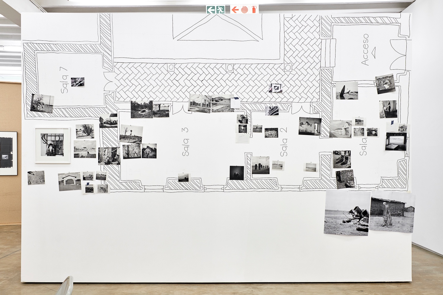 Installation photograph from the 2018 rendition of ‘Parallel Play’ in A4’s Gallery. A moveable gallery wall is features the sketched layout of an exhibition space, with photographic prints from Jo Ractliffe’s archive pinned on top of it.
