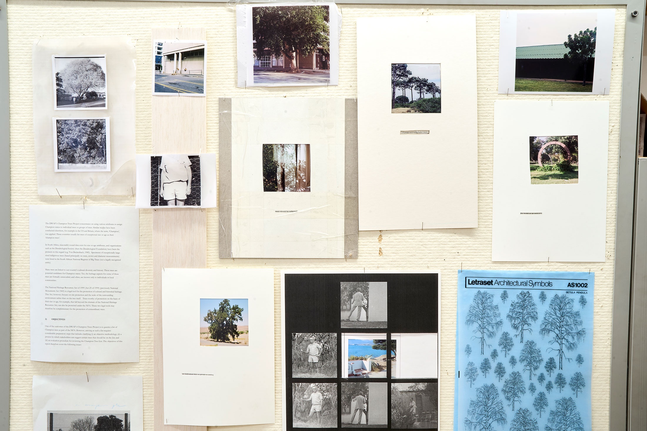 Installation photograph of Michael Tymbios’ studio during his residency in A4 Arts Foundation. A closeup view of a freestanding pinboard that features multiple text printouts and photographic prints.
