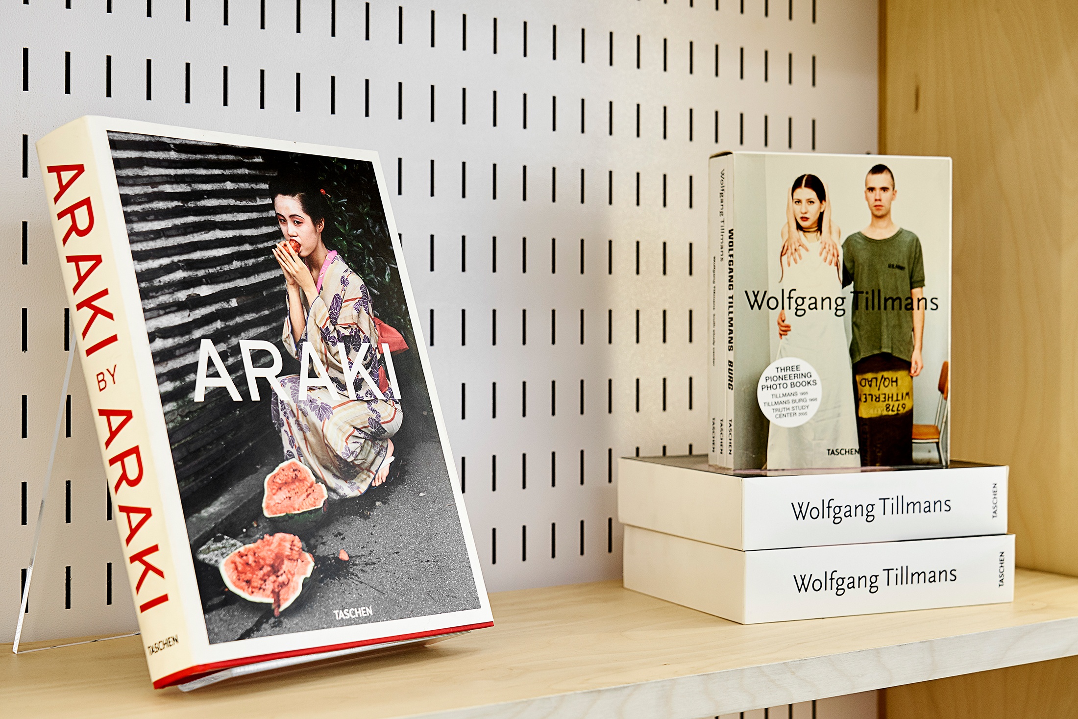Installation photograph from the Taschen pop-up in A4’s Proto~ museum shop. A close-up view of a cabinet shelf showcases ‘Araki’ by Araki on the left, and a bundle of three photo books by Wolfgang Tillmans on the right.
