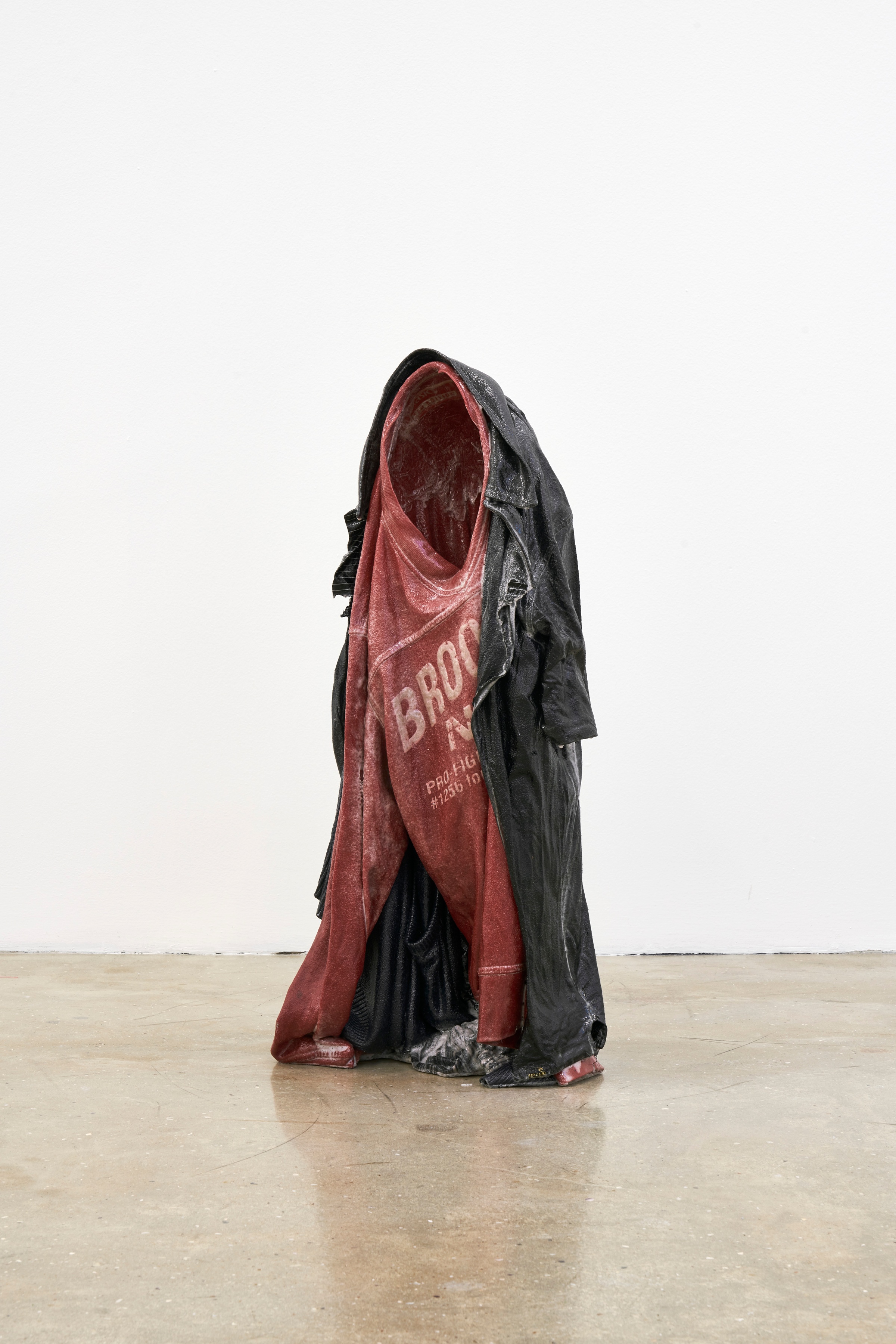 A photograph of Kevin Beasley's garment and resin sculpture 'Untitled (Brooklyn kid)' standing on a concrete floor.

