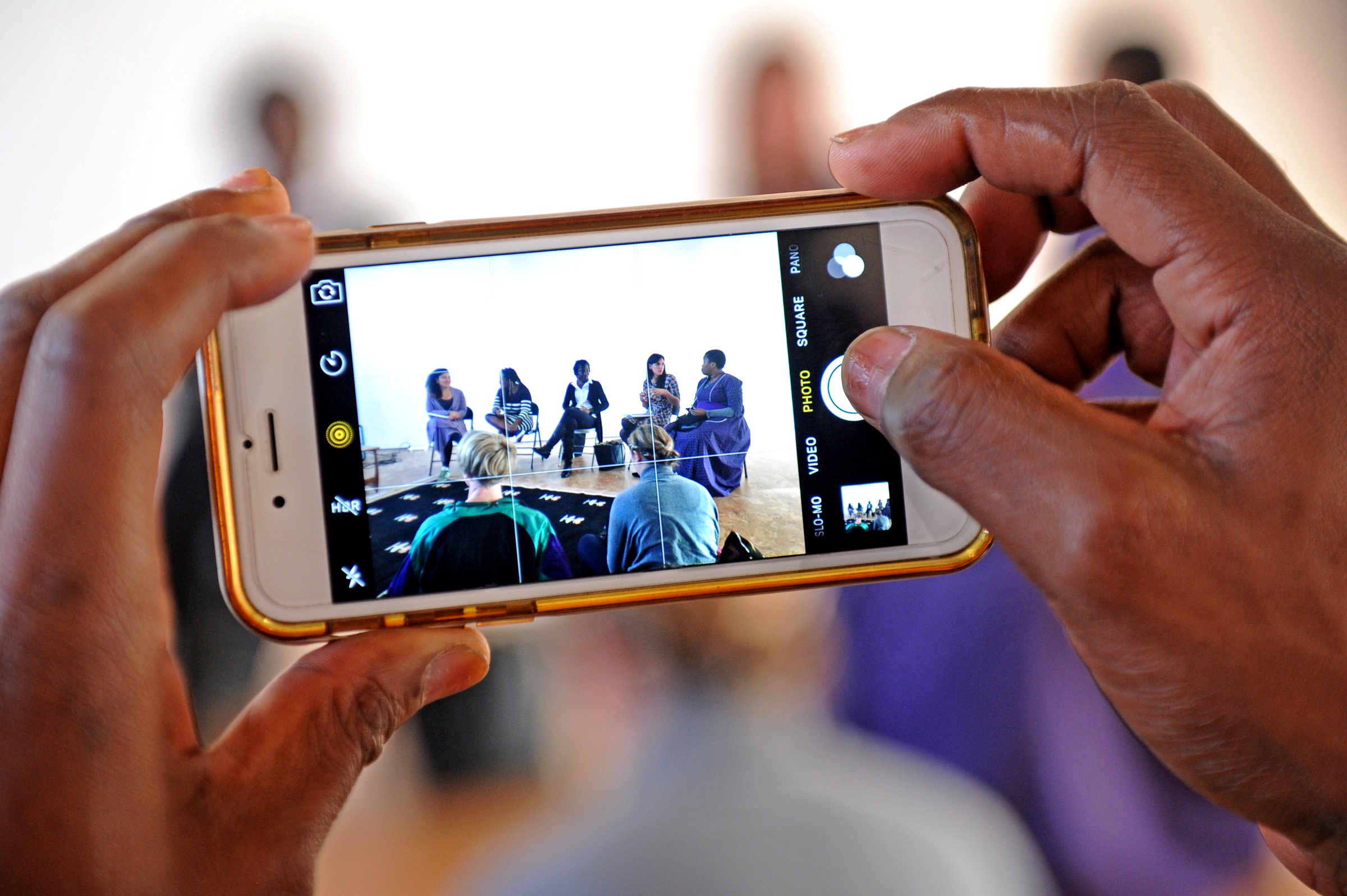 Event photograph from ‘Storied Woman’ on A4’s top floor that shows someone taking a photograph of the speakers on a cellphone.
